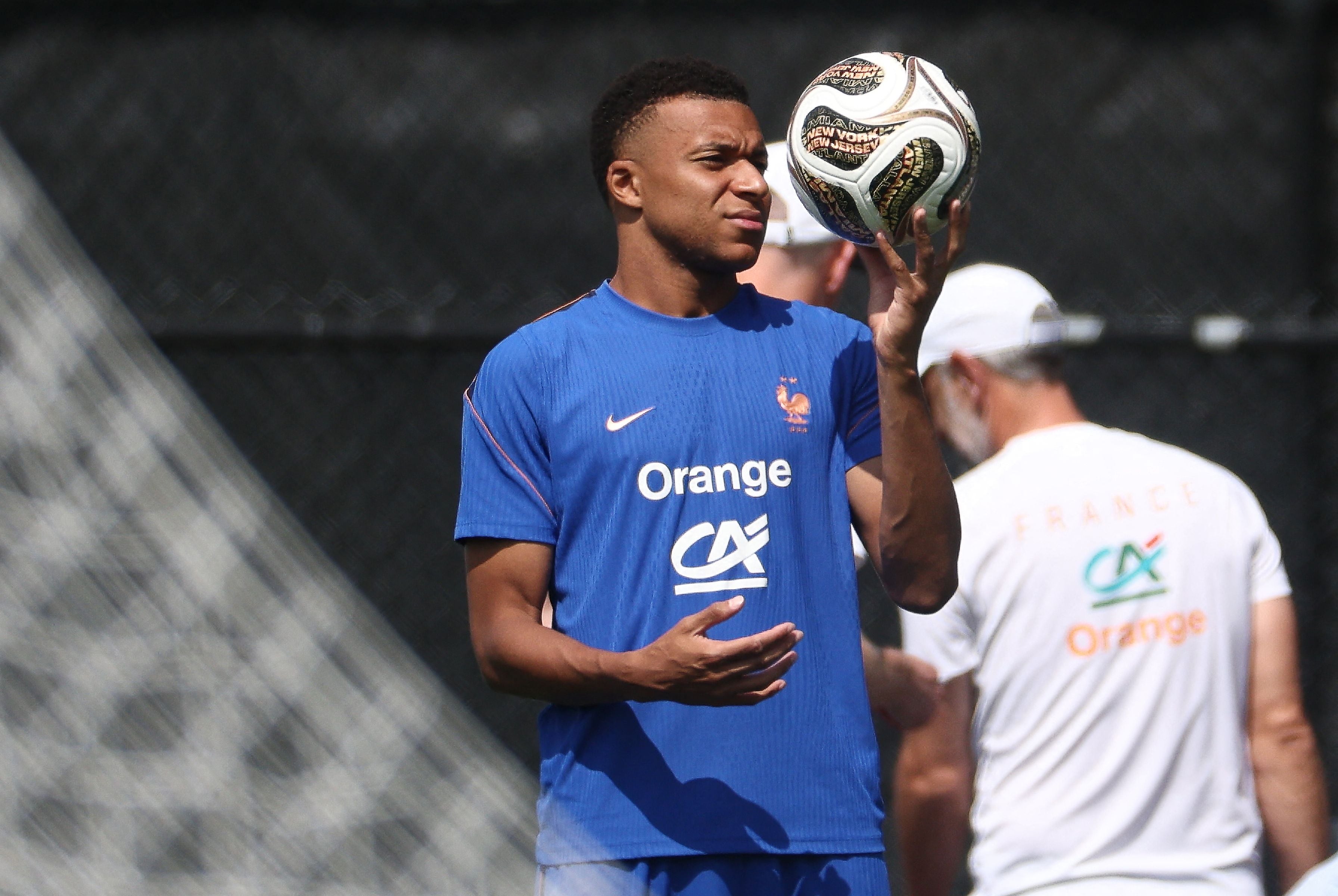 Ein Fußballspieler im blauen Frankreich-Trikot balanciert einen Ball auf der Hand.