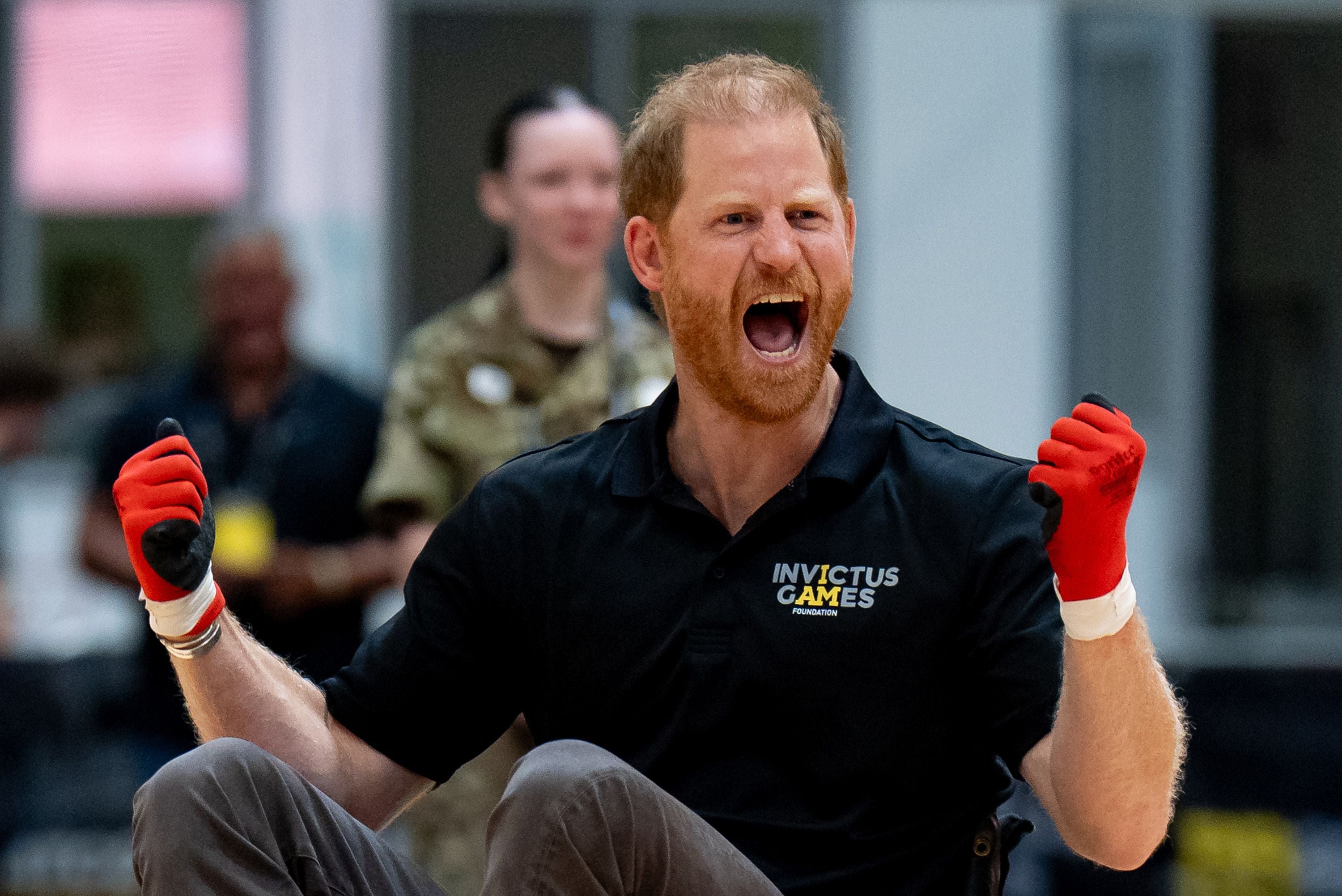 Ein jubelnder Mann im Rollstuhl mit roten Handschuhen bei den Invictus Games.