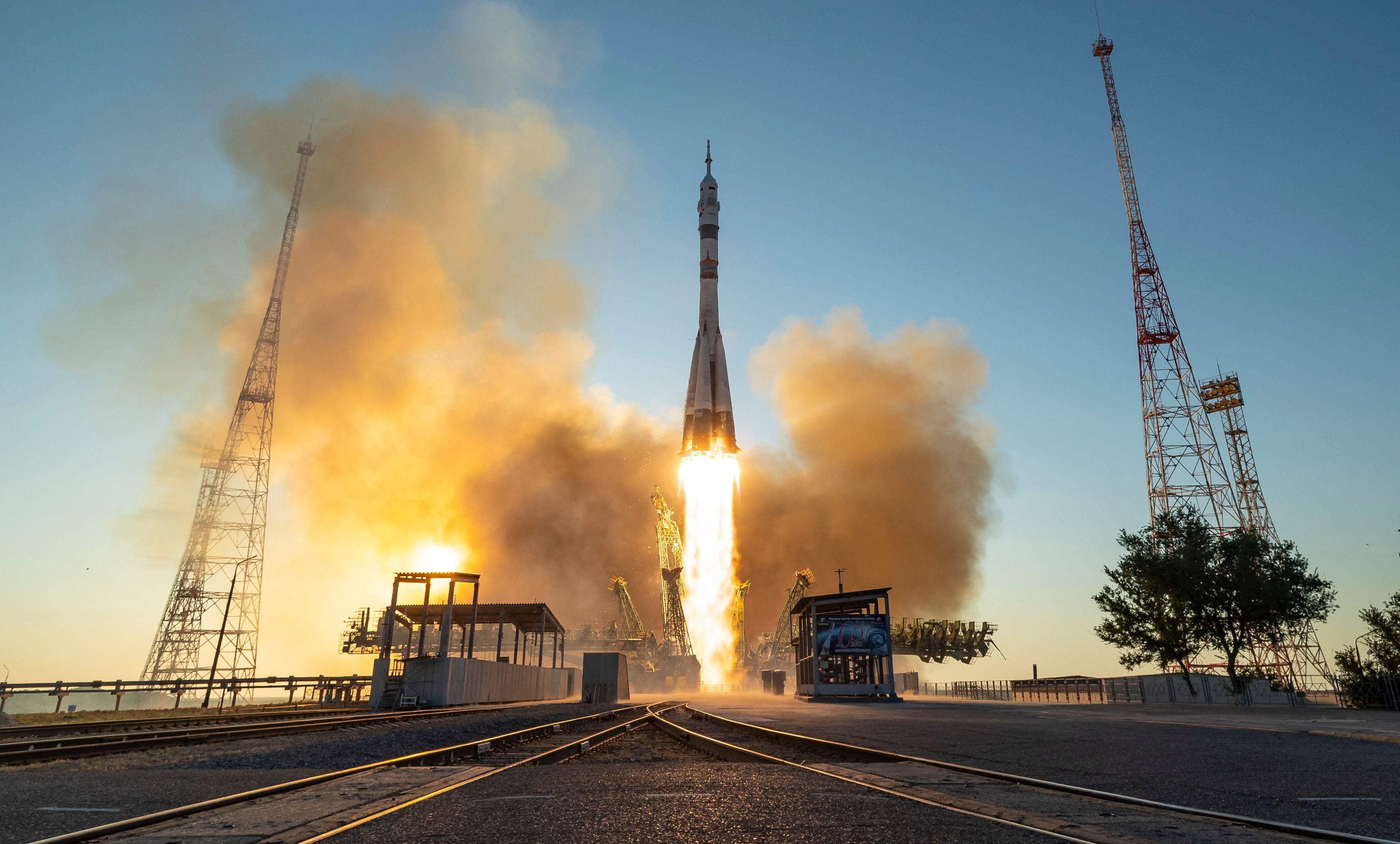 Eine Rakete startet mit Flammen- und Rauchentwicklung am frühen Morgen vom Weltraumbahnhof.