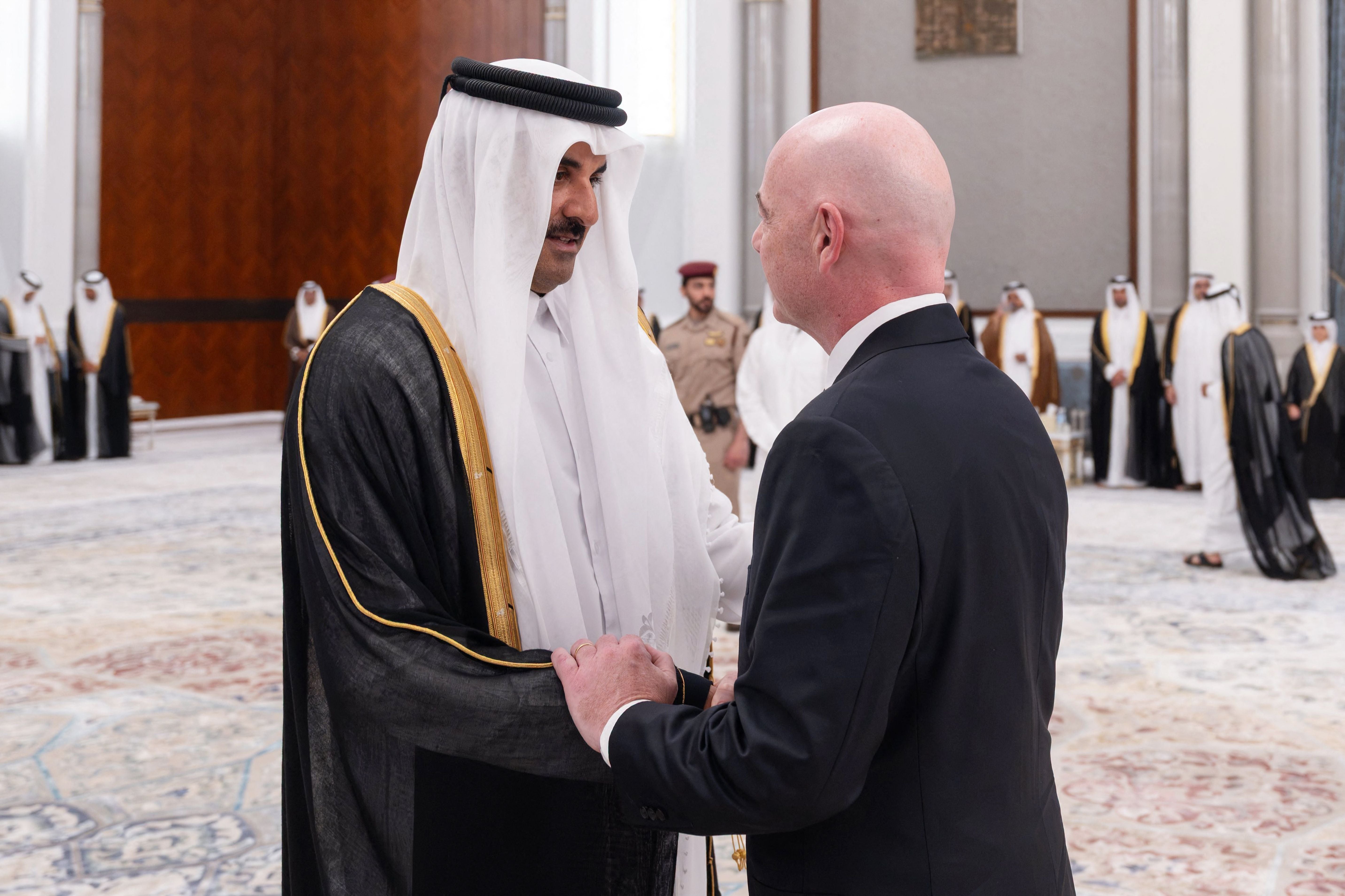 This handout photograph taken and released by Qatar's Amiri Diwan on July 13, 2026 shows Qatar's Emir Sheikh Tamim bin Hamad Al Thani (L) receiving condolences from FIFA President Gianni Infantino, following the death of his father, former leader Sheikh Hamad bin Khalifa Al Thani, at the Lusail Palace on the outskirts of Doha. Qatar's government on July 12 announced the death of former leader Sheikh Hamad bin Khalifa Al Thani, who led the country from 1995 to 2013. He was 74, according to a government website. Sheikh Hamad was seen as one of the architects of modern Qatar and led the country during a period of rapid economic growth. (Photo by Qatar's Amiri Diwan / AFP) / RESTRICTED TO EDITORIAL USE - MANDATORY CREDIT 'AFP PHOTO / QATAR'S AMIRI DIWAN' - HANDOUT - NO MARKETING NO ADVERTISING CAMPAIGNS - DISTRIBUTED AS A SERVICE TO CLIENTS