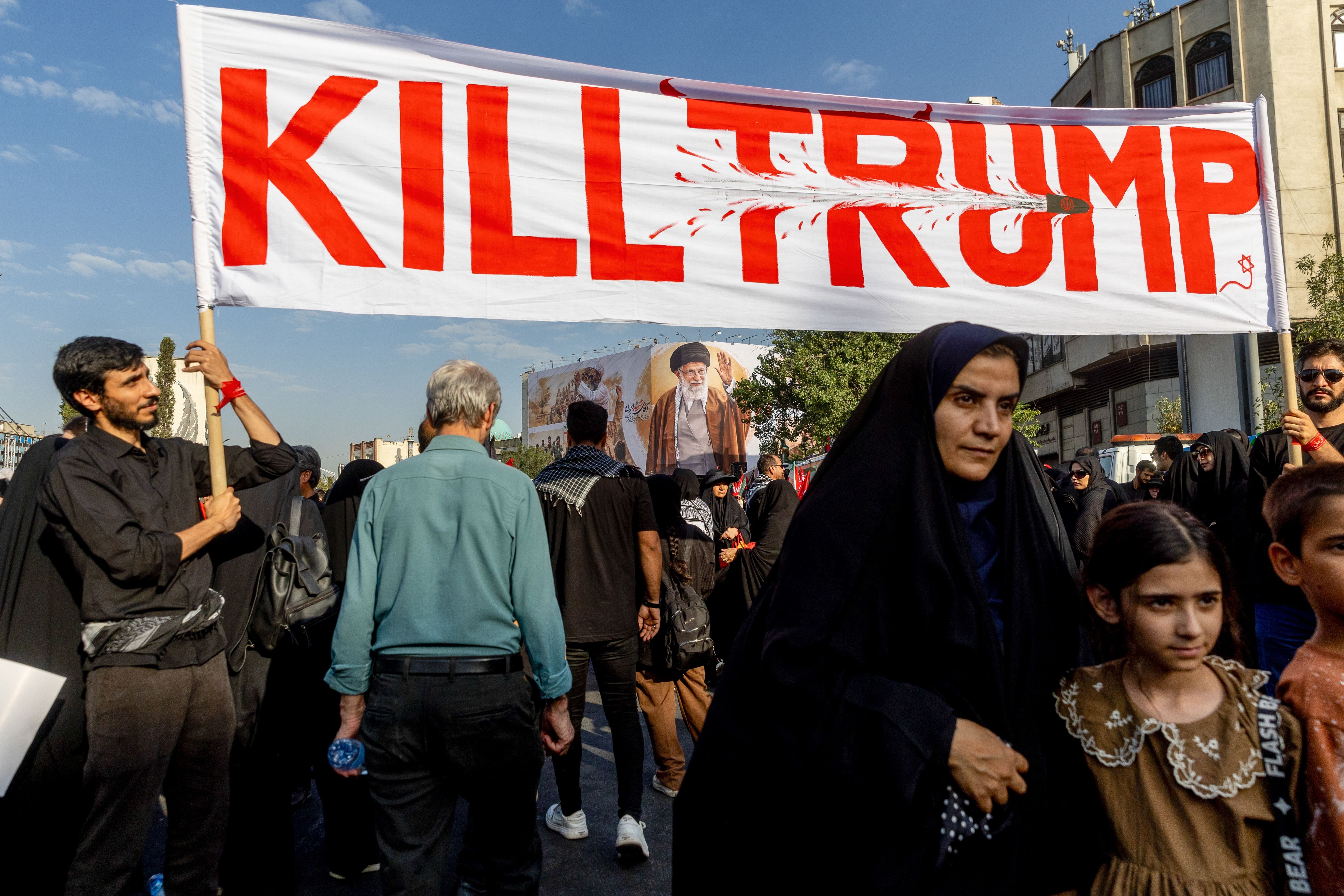 Menschen halten ein Banner mit der Aufschrift "Kill Trump" bei einer Trauerkundgebung in Teheran.