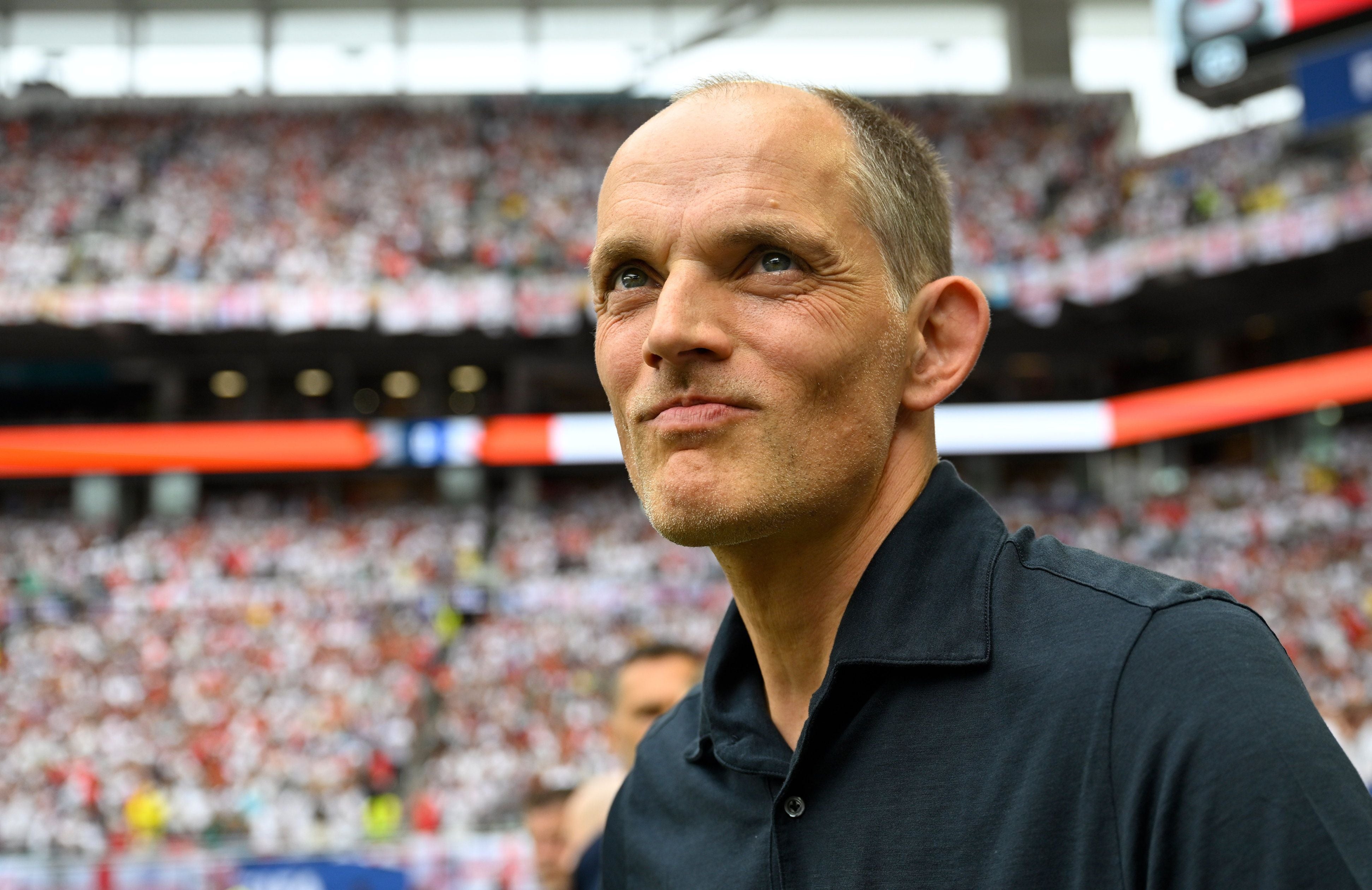 Ein Mann in einem schwarzen Hemd steht im Stadion vor einer großen Menschenmenge.