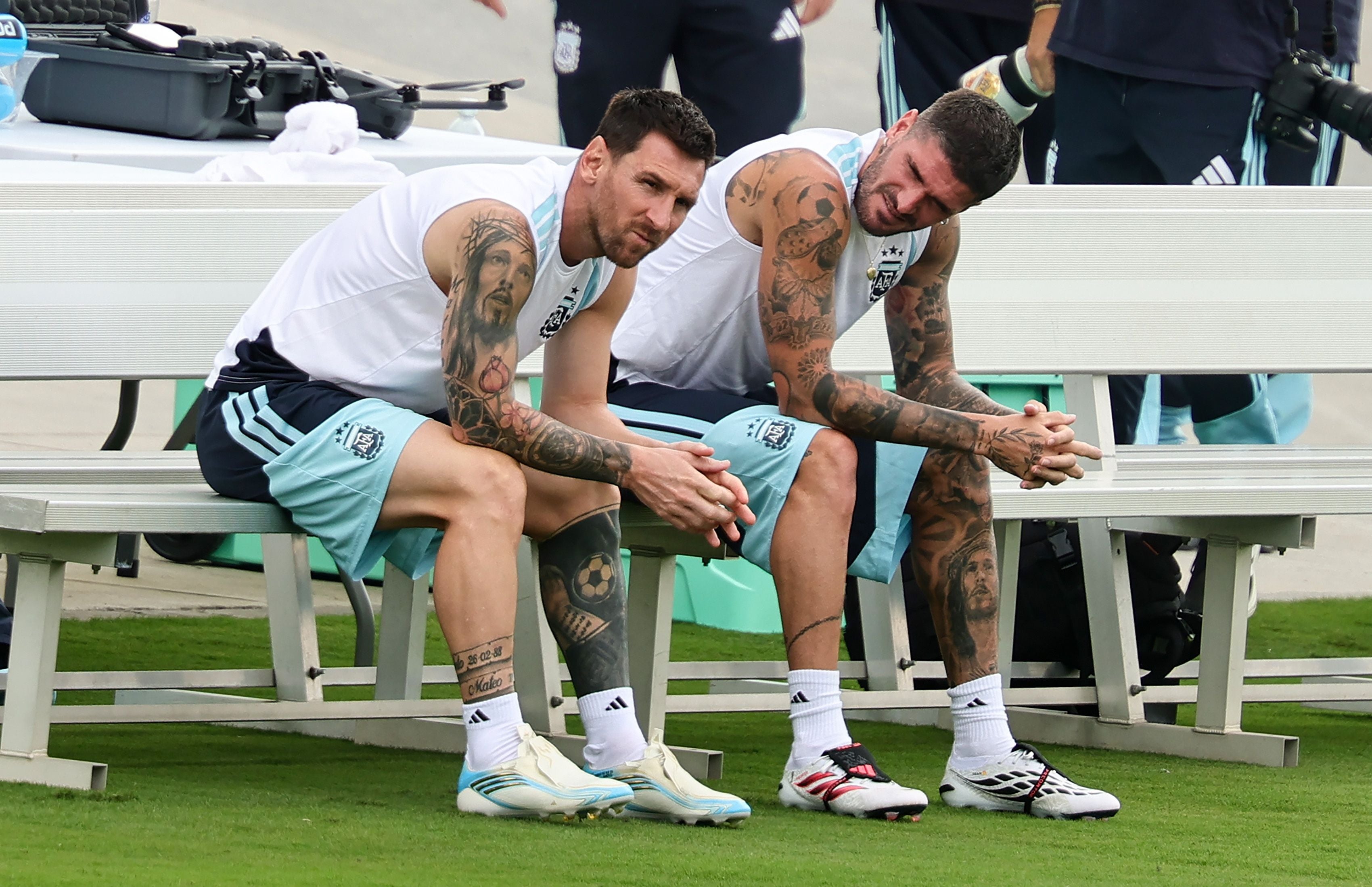 Zwei argentinische Fußballspieler sitzen während eines Trainings auf einer Bank am Spielfeldrand.