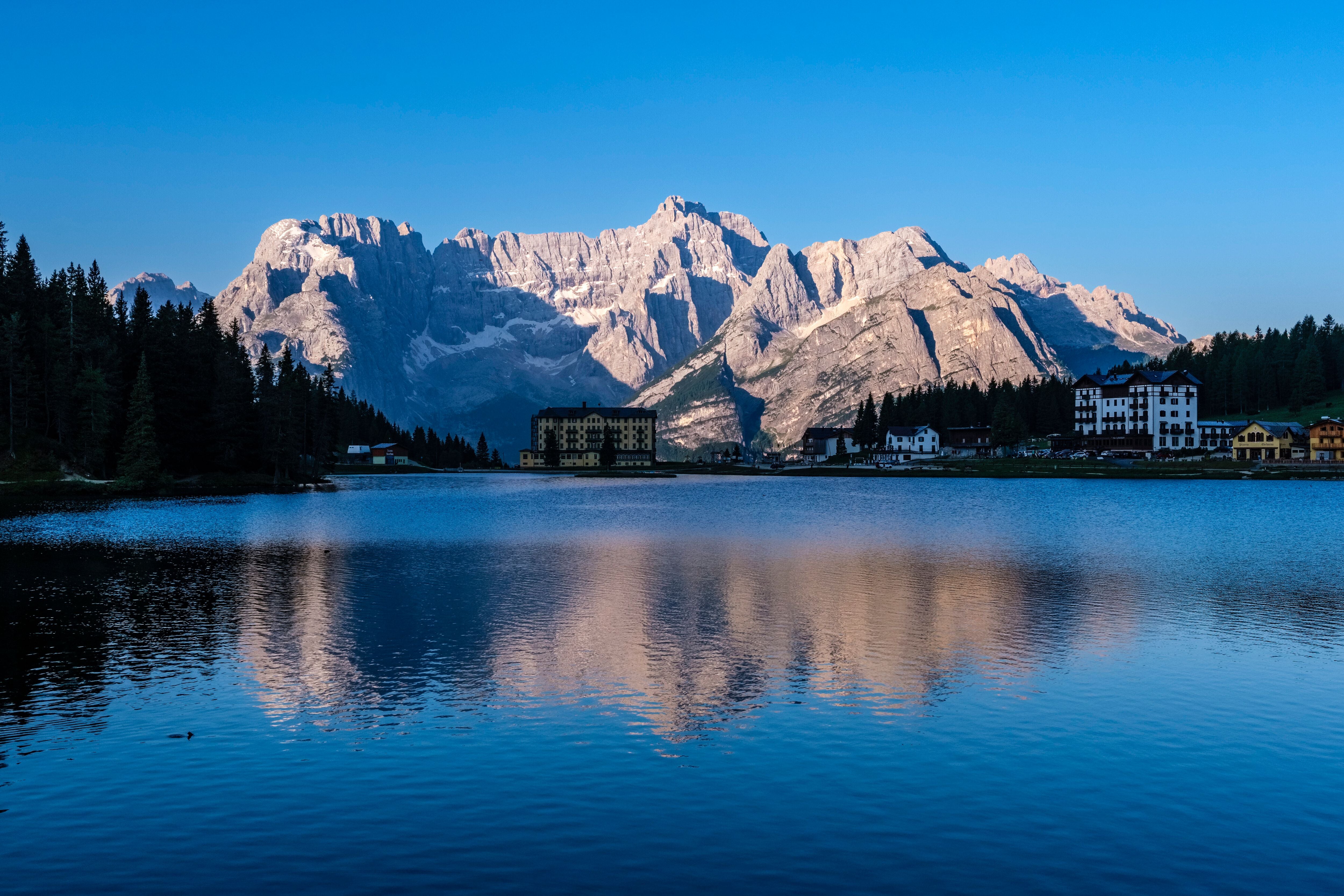 Blick auf den Misurinasee, das Dorf Misurina und Dolomiten im Hintergrund bei Sonnenlicht.