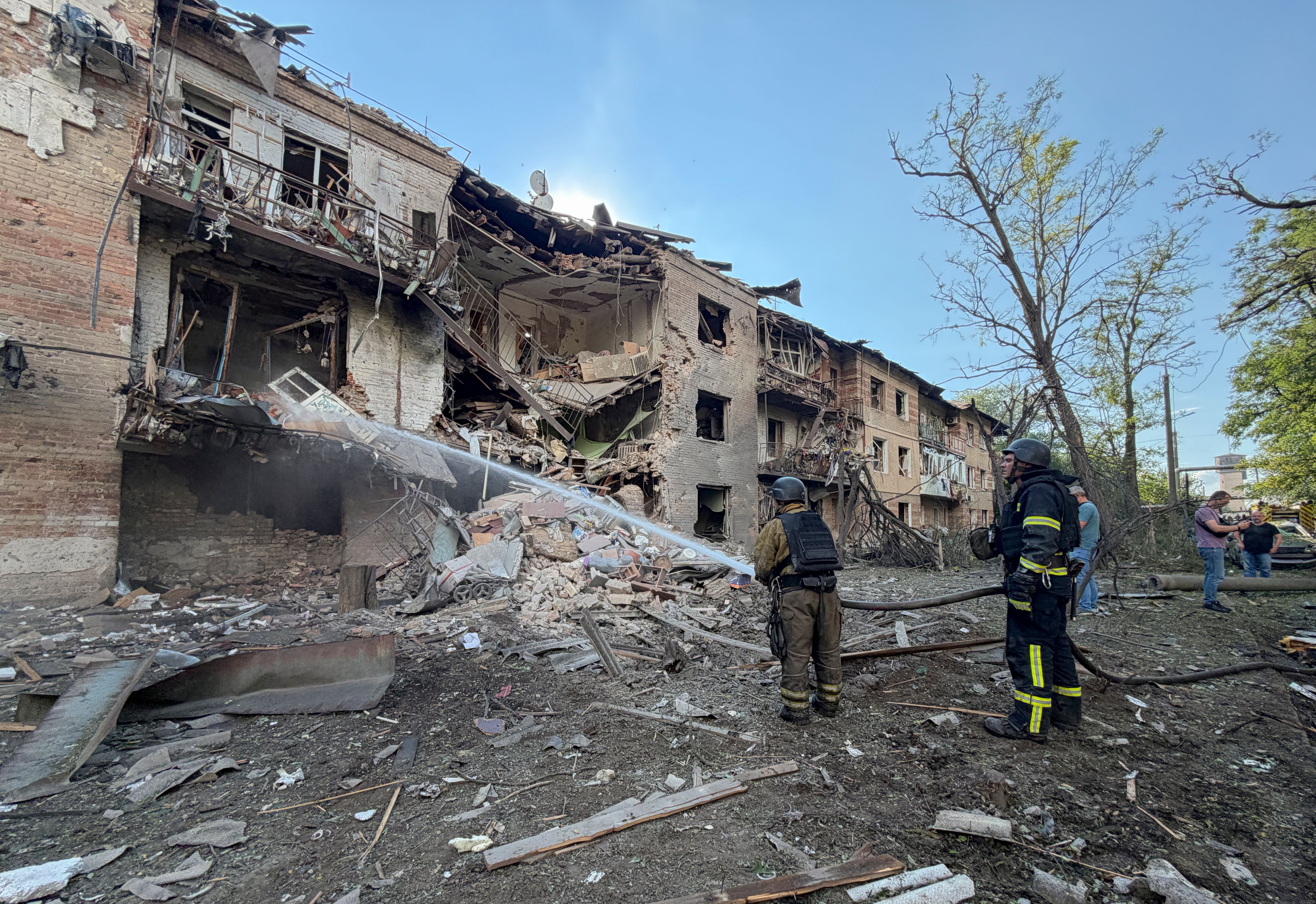 Feuerwehrleute löschen ein schwer beschädigtes Wohnhaus nach einem Luftschlag in Zaporizhzhia.