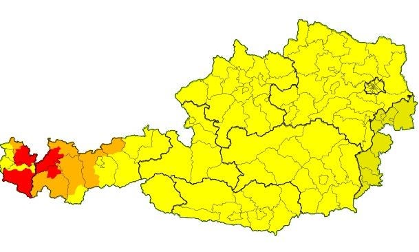 Unwetterwarnkarte für Österreich mit roten, orangen und gelben Gewitterwarnungen, besonders im Westen.