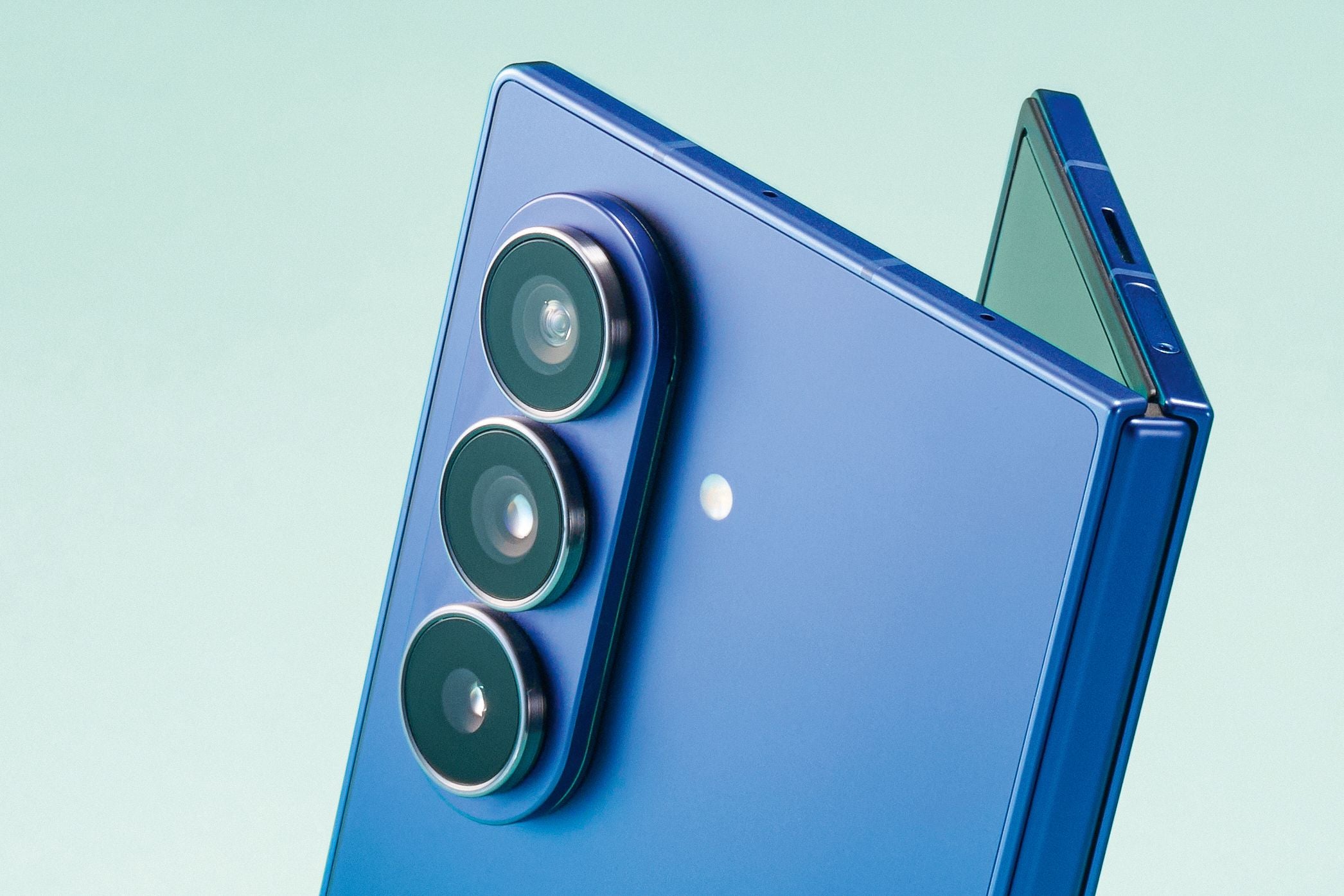 Nahaufnahme eines blauen Samsung Galaxy Z Fold7 Flip-Smartphones mit drei Kameralinsen.