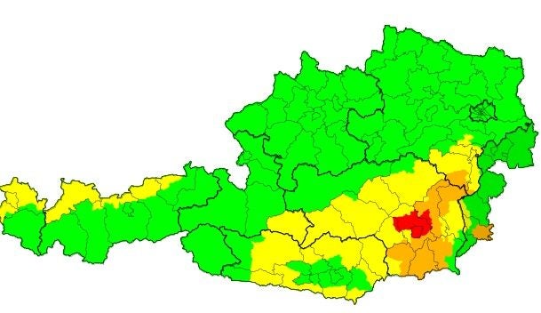 Unwetterkarte von Österreich mit Regionen in Grün, Gelb, Orange und Rot markiert.