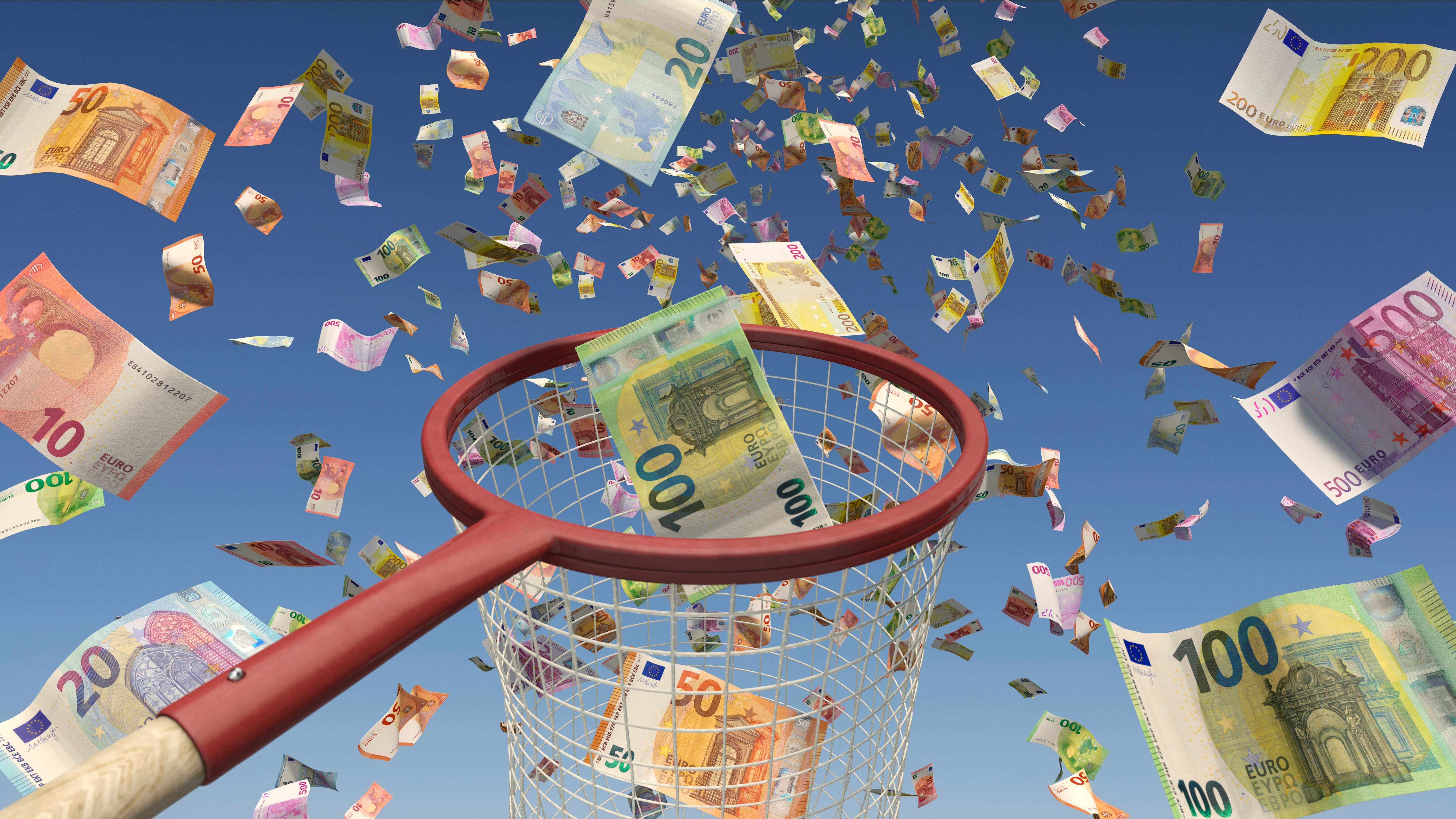 Viele Eurobanknoten fliegen durch die Luft, ein Kescher fängt einige davon ein.