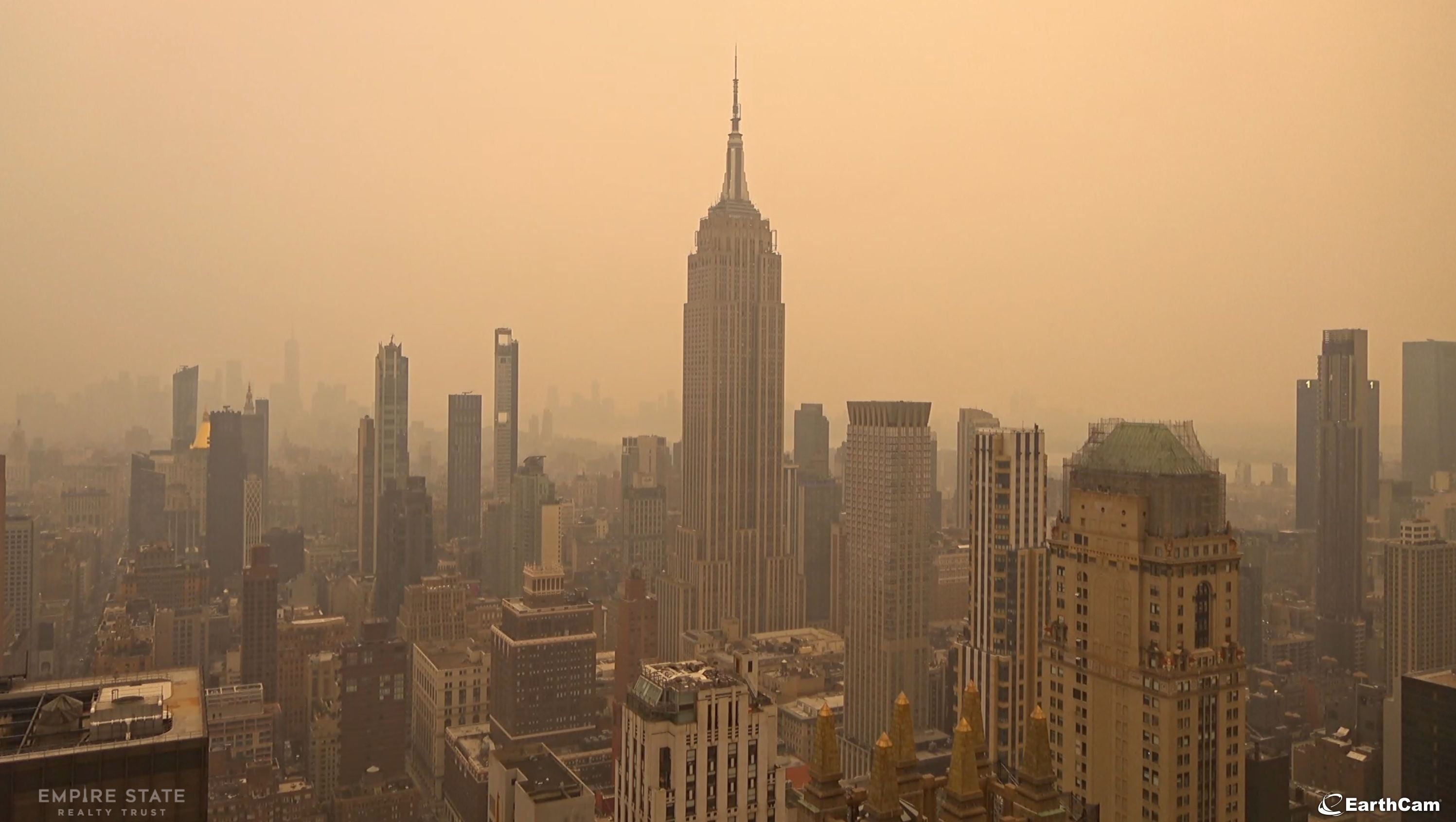 Die Skyline von New York mit dem Empire State Building unter gelblich-dunstigem Himmel.