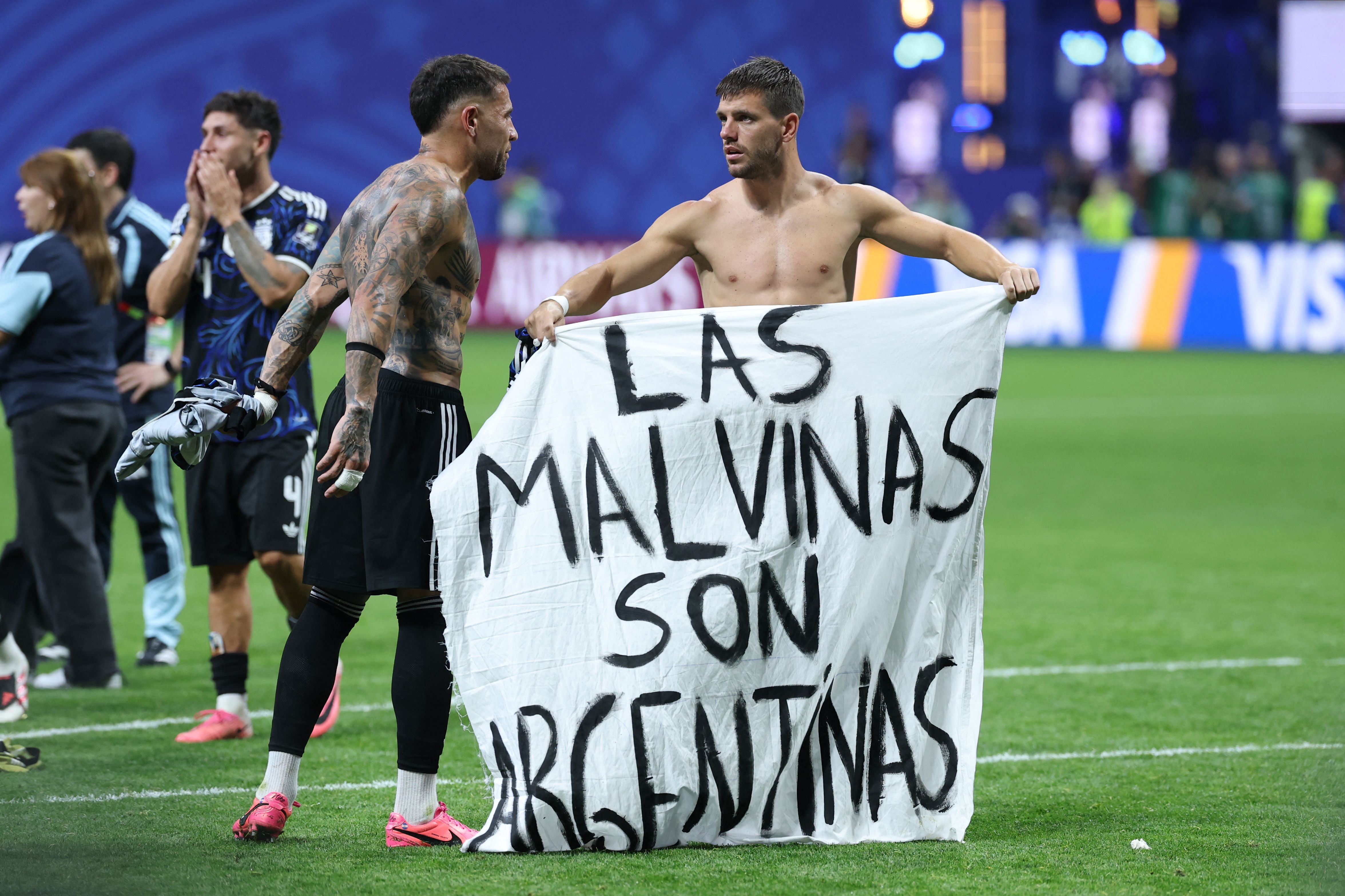 Argentinische Fußballspieler halten ein Banner mit der Aufschrift „Las Malvinas son Argentinas“.