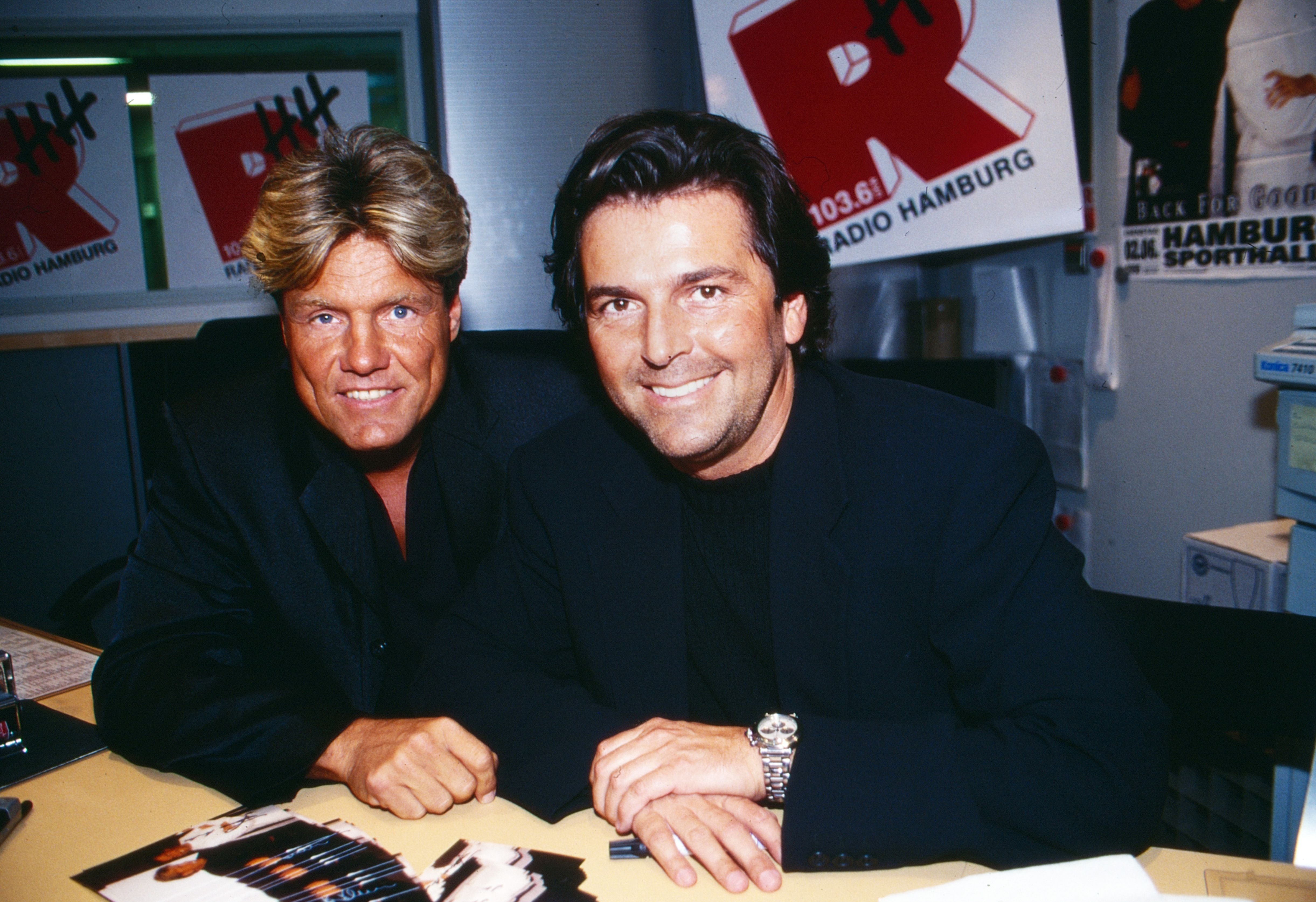 Zwei Männer in dunkler Kleidung sitzen am Tisch bei Radio Hamburg, circa 1997.