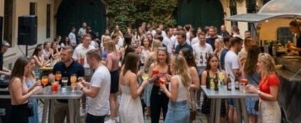 Viele junge Menschen feiern und trinken Cocktails bei einer Sommer-Pop-up-Bar im Freien.