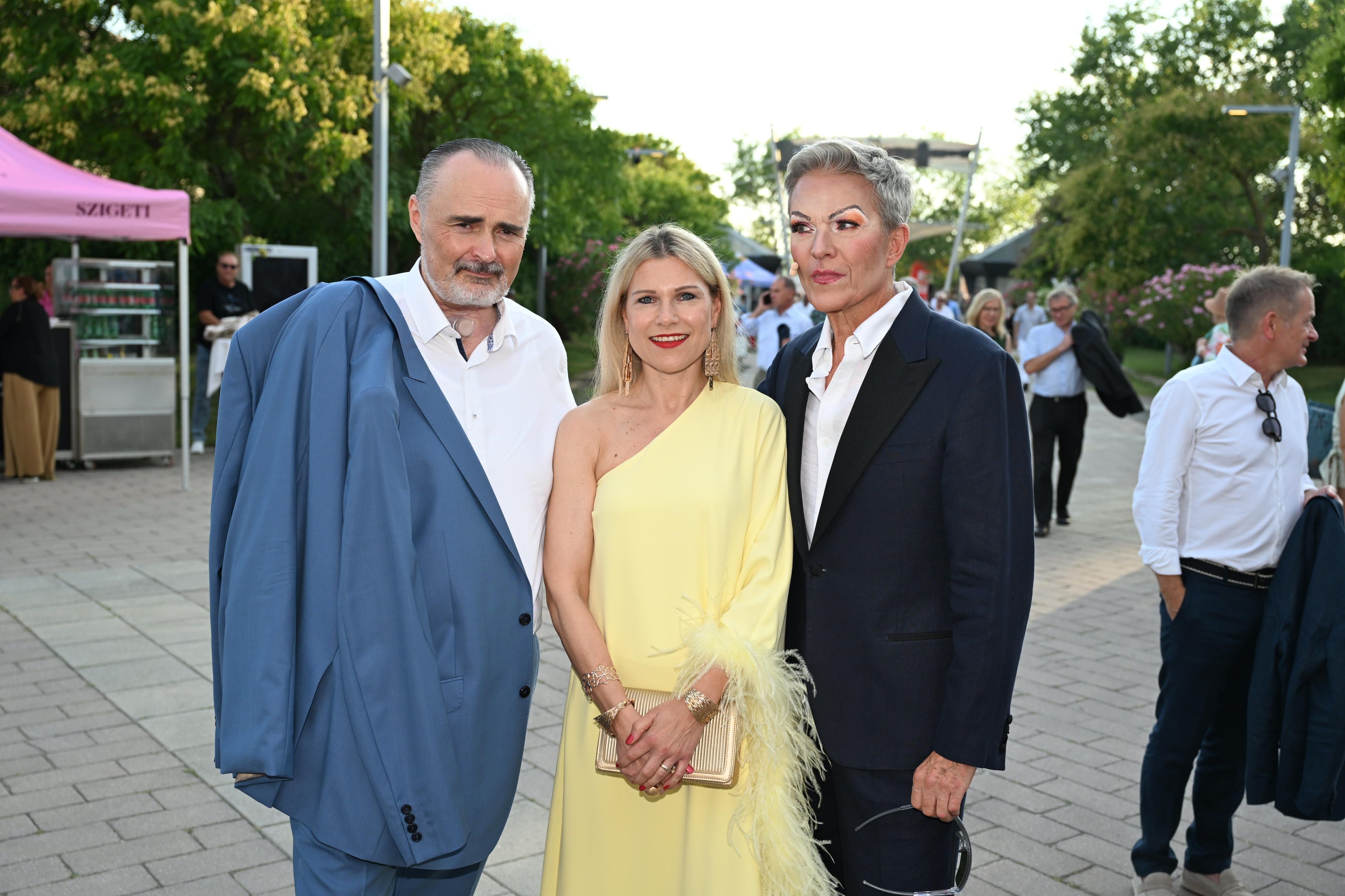 Drei elegant gekleidete Personen posieren bei den Seefestspielen Mörbisch im Freien.