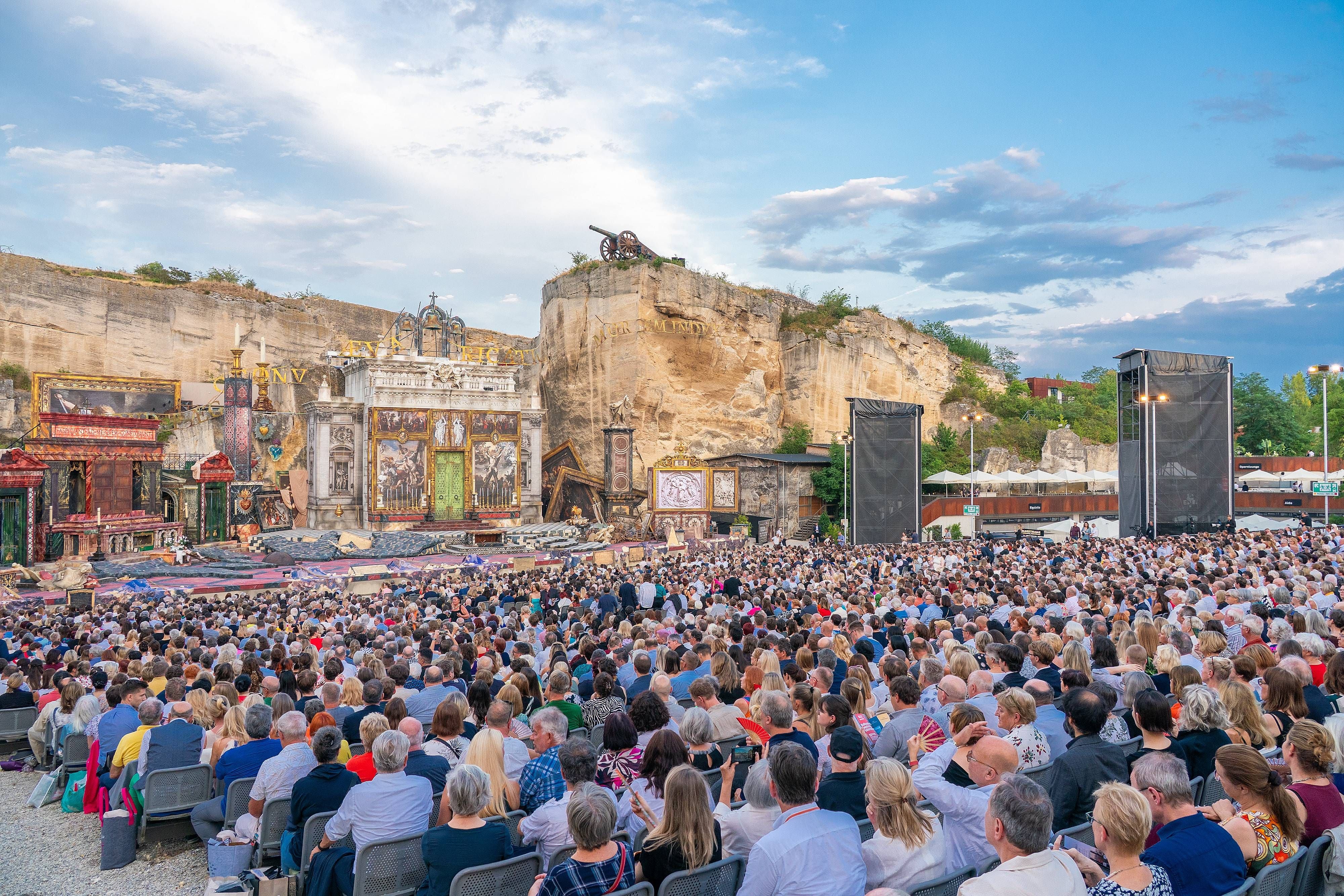 Großes Publikum sitzt im Steinbruch St. Margarethen vor einer Freilichtbühne bei den Opernfestspielen.