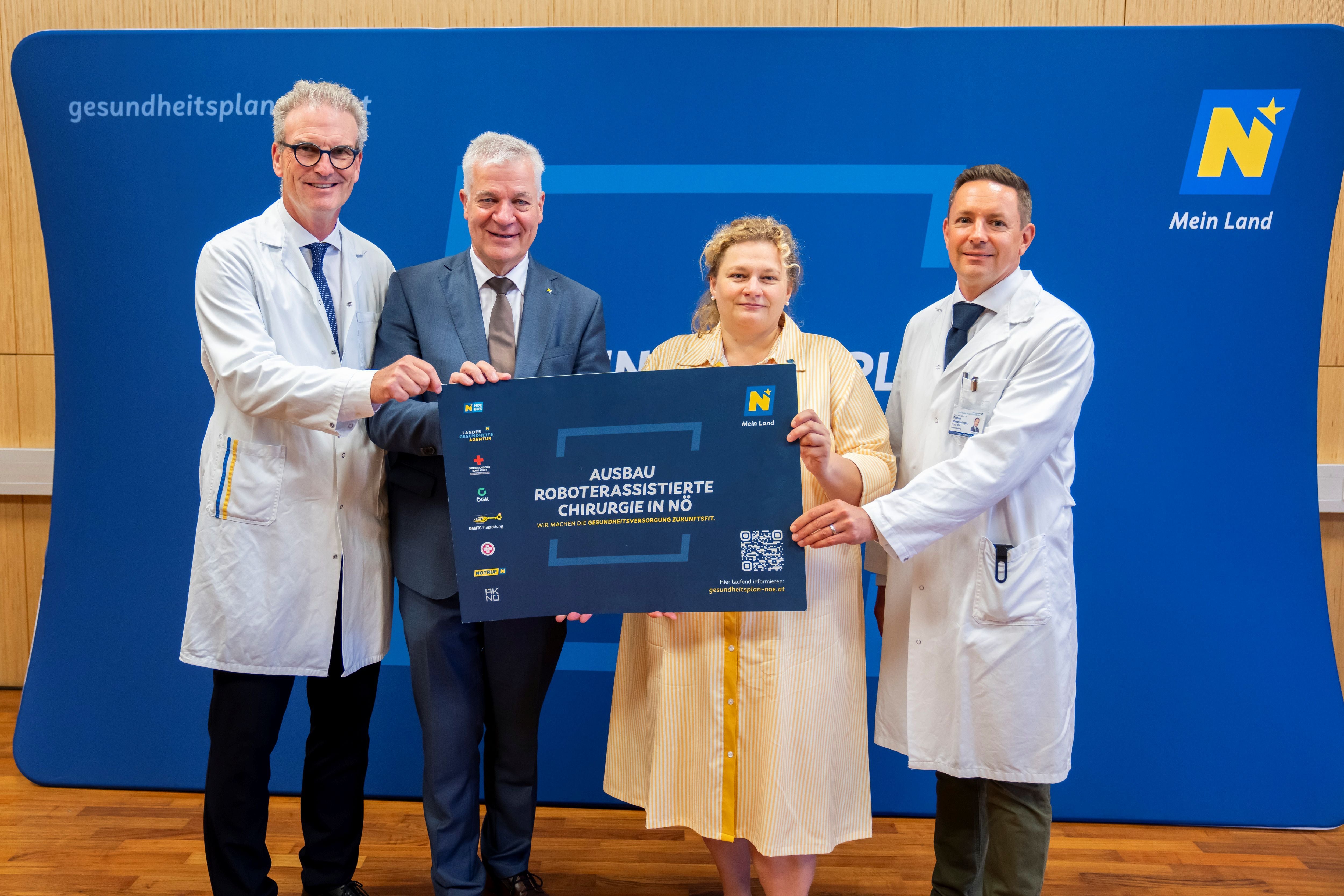 Vier Personen halten ein Schild zum Ausbau roboterassistierter Chirurgie in Niederösterreich.