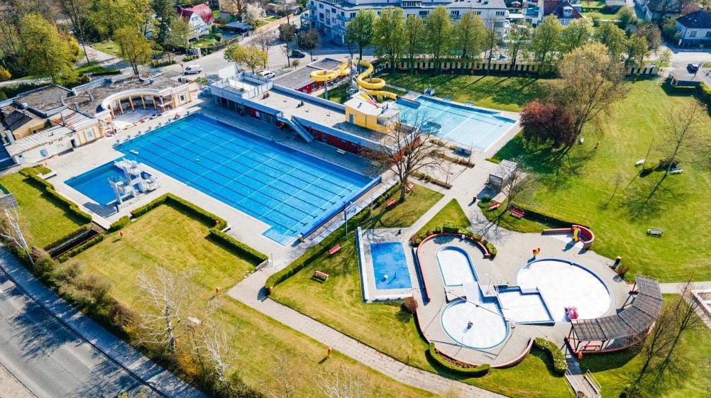 Luftaufnahme eines Freibads mit Becken, Rutschen und Liegewiesen in St. Pölten.