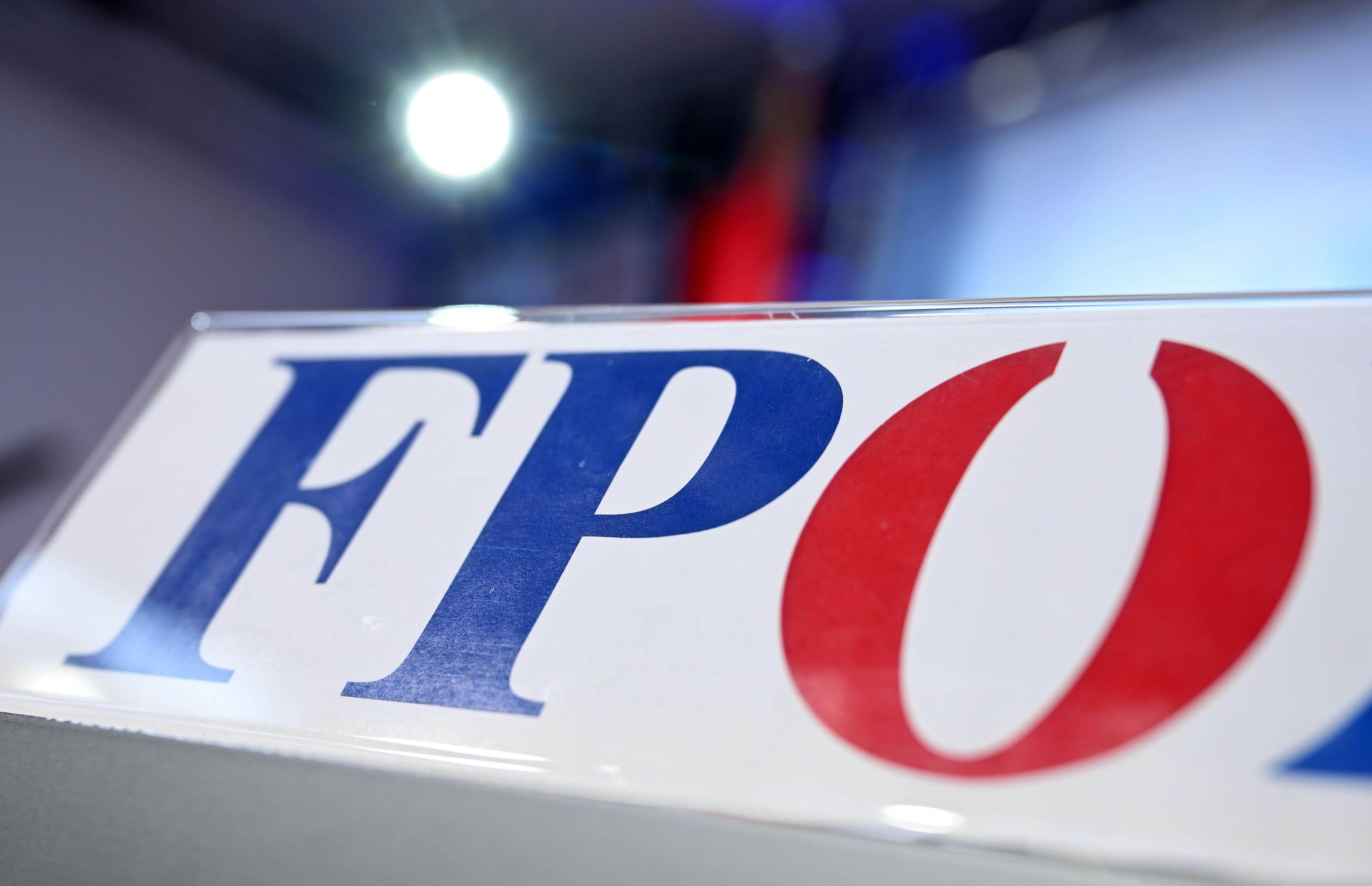 Nahaufnahme des FPÖ-Logos mit unscharfem Hintergrund und Lichtreflexionen.