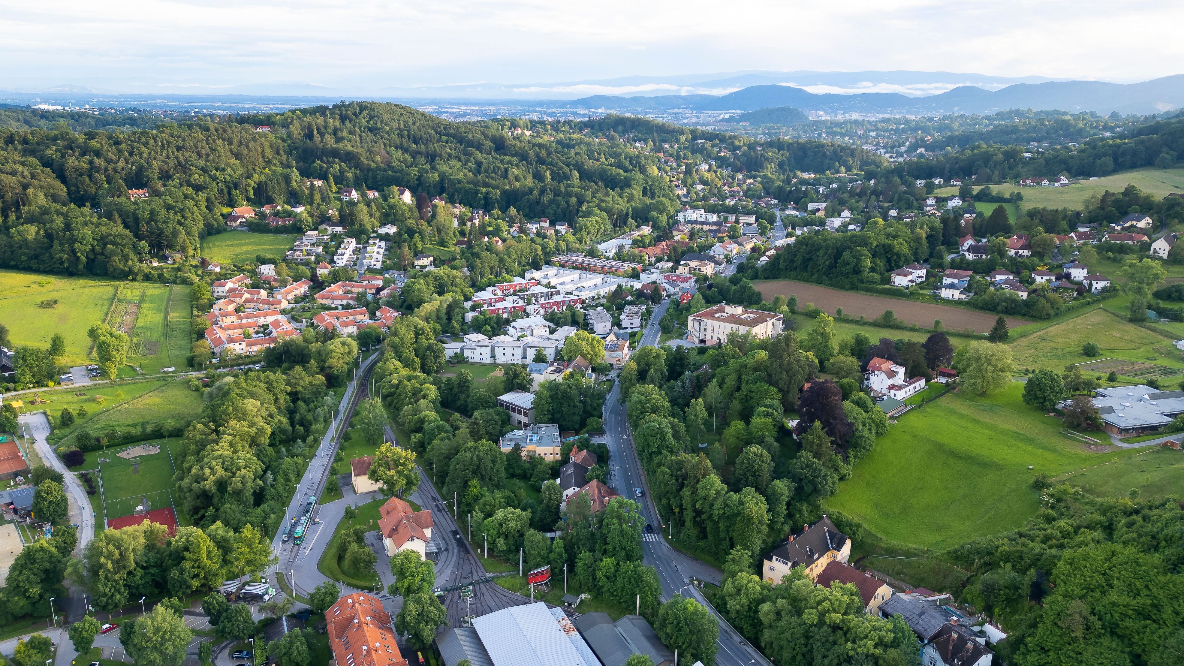 Zwei Reinigungskräfte tragen Putzutensilien wie Eimer und Wischmopp in einem Flur.