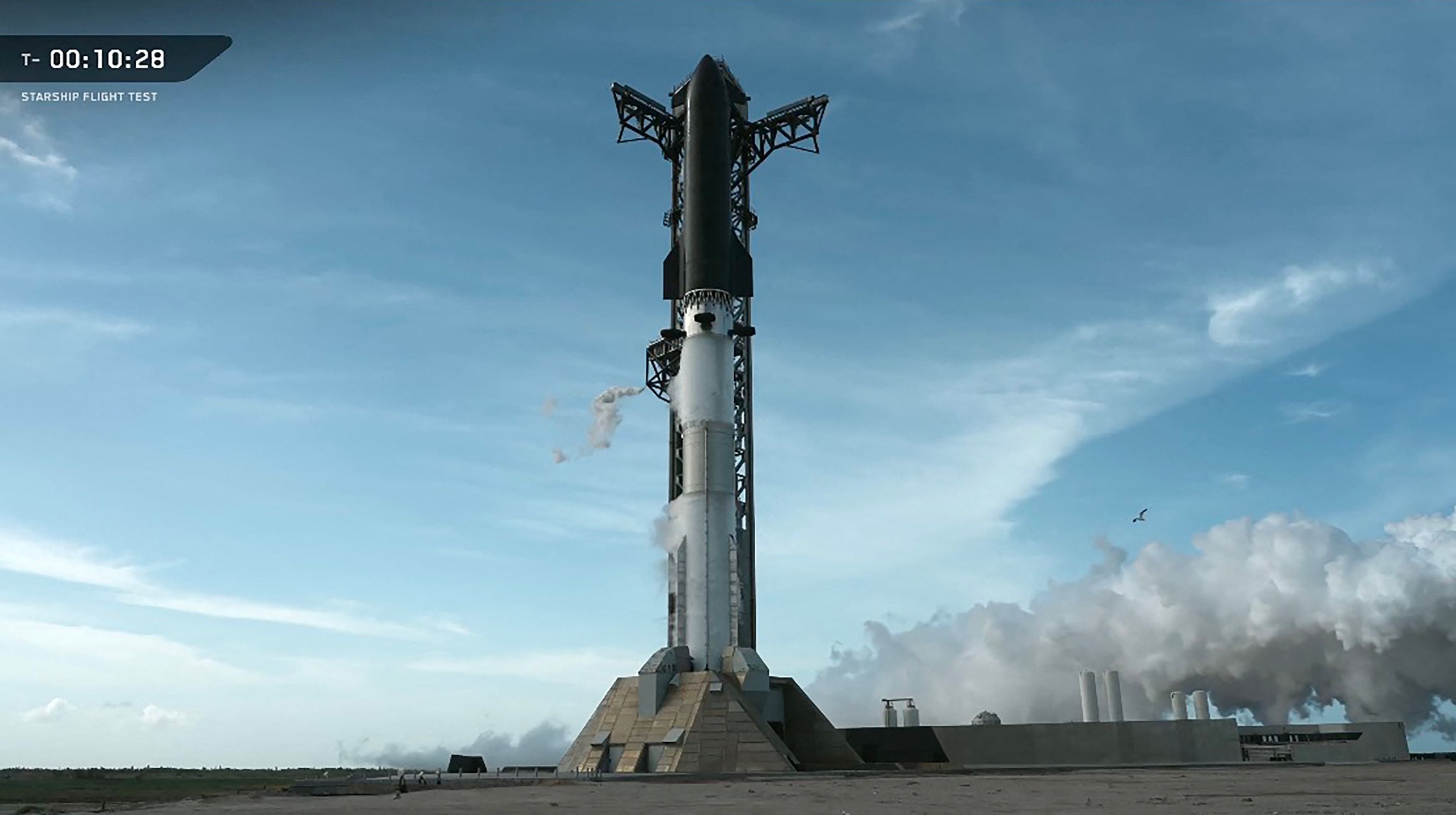 Die SpaceX Starship-Rakete steht startbereit auf der Startrampe unter blauem Himmel.