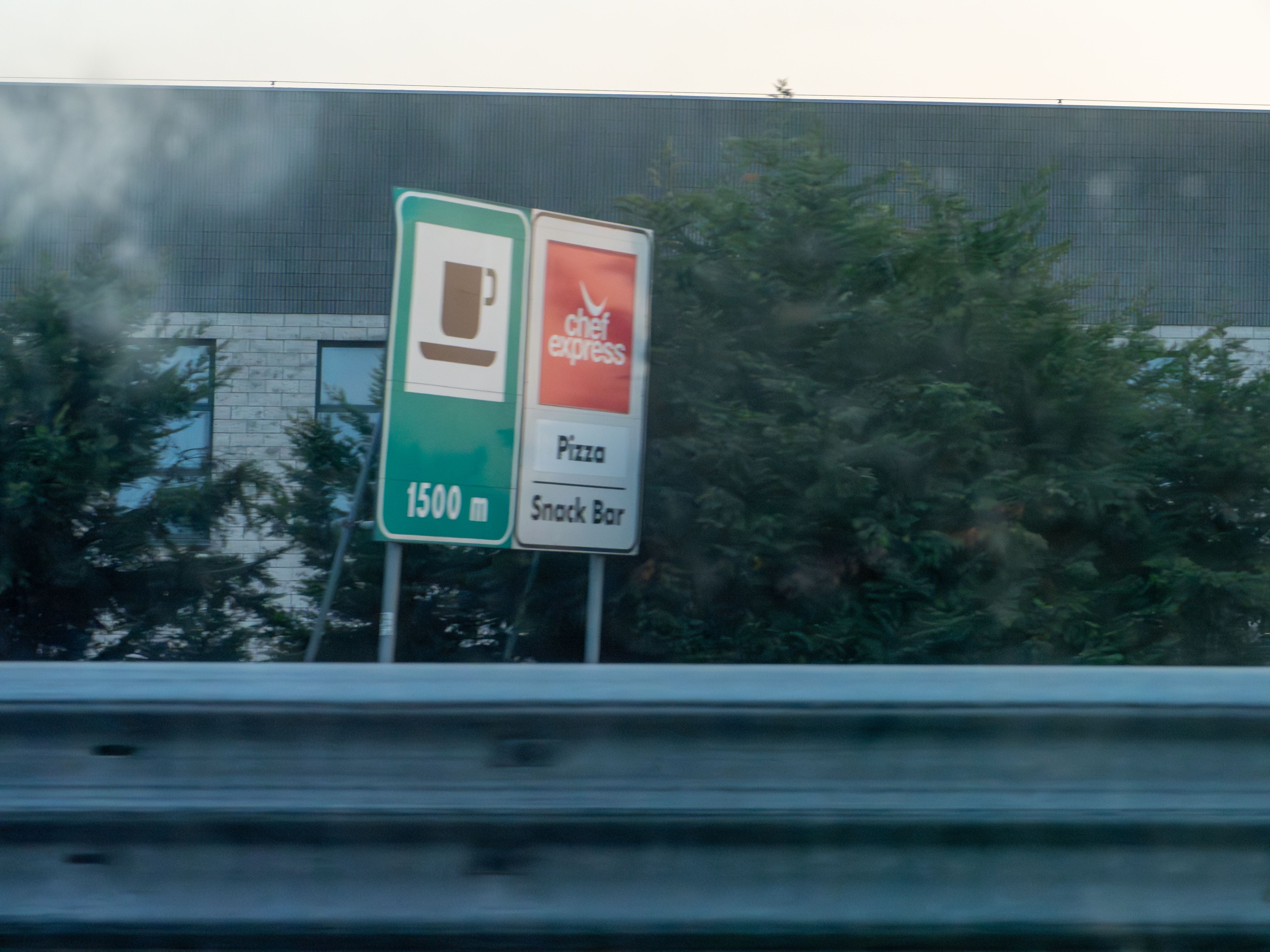 Zwei Autobahnschilder informieren über Café, Pizza und Snack Bar in 1.500 Metern Entfernung.