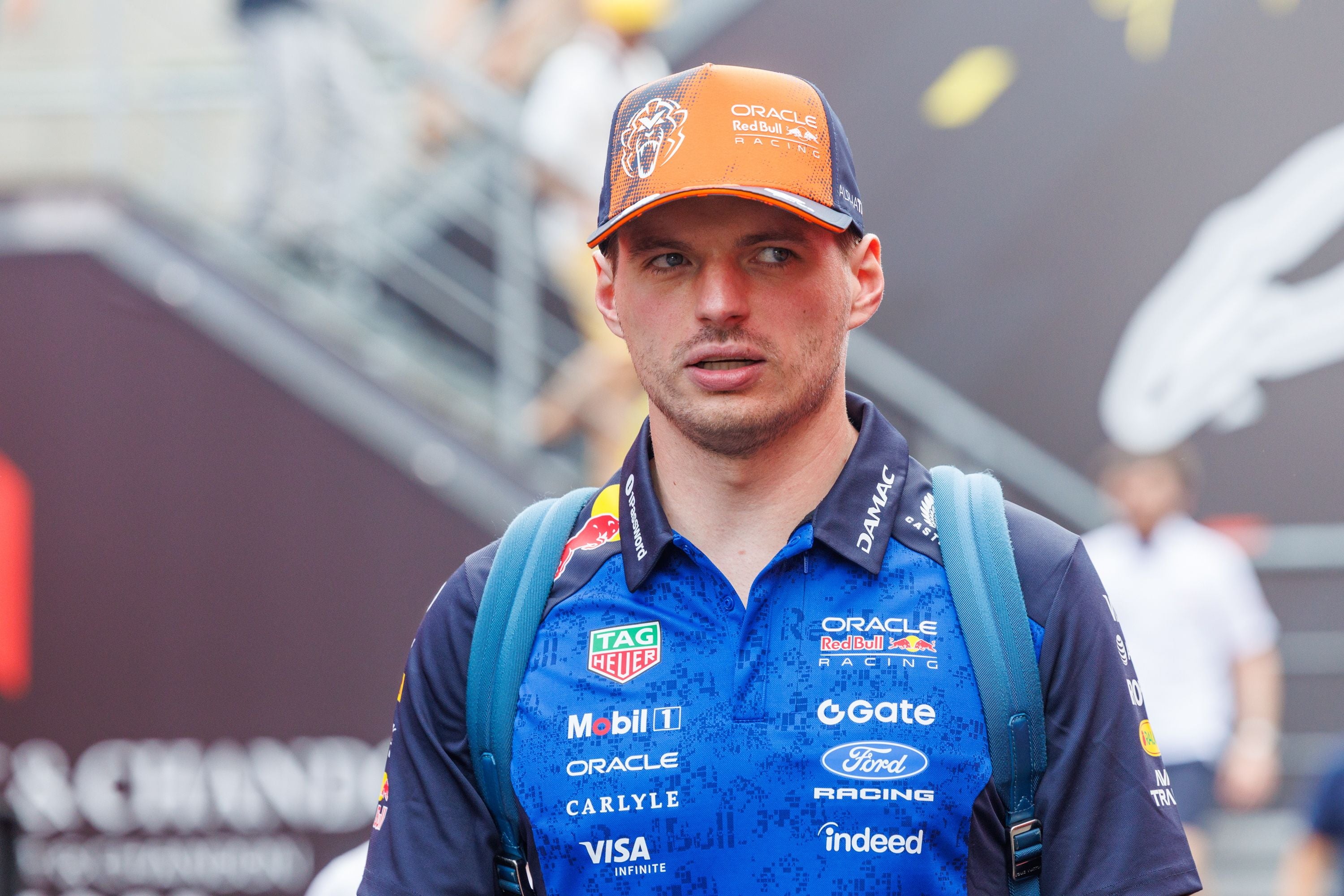 Ein Mann im Red Bull Racing Outfit und Cap läuft mit Rucksack durch die Boxengasse.