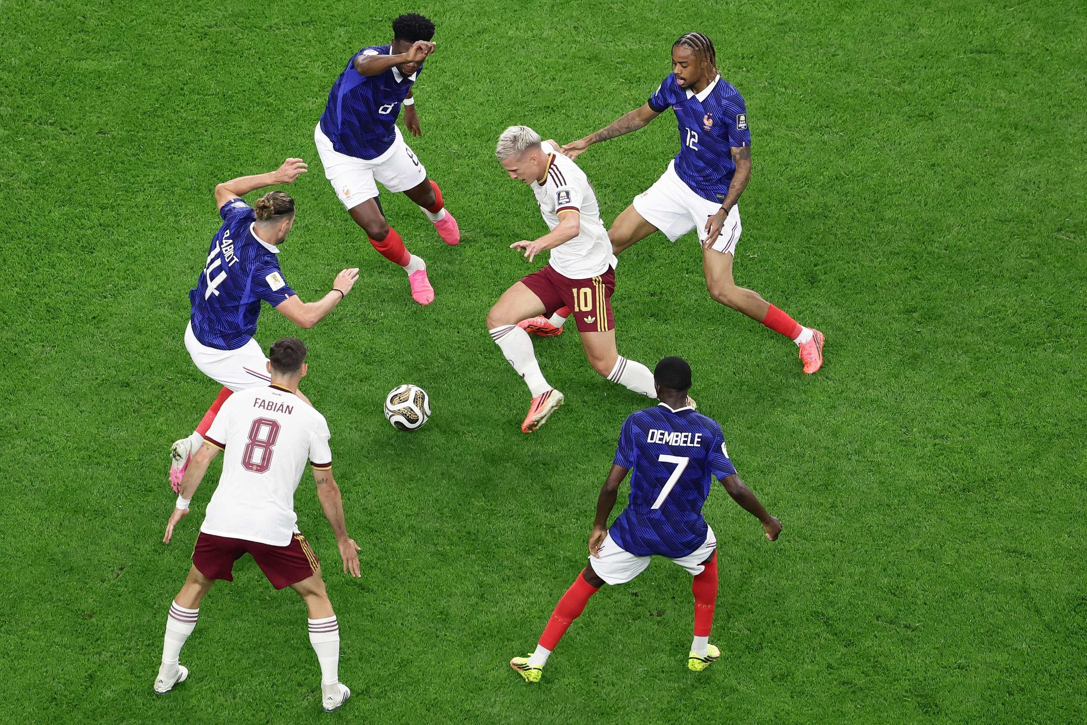 Dani Olmo wird von vier französischen Spielern beim Fußballspiel um den Ball bedrängt.