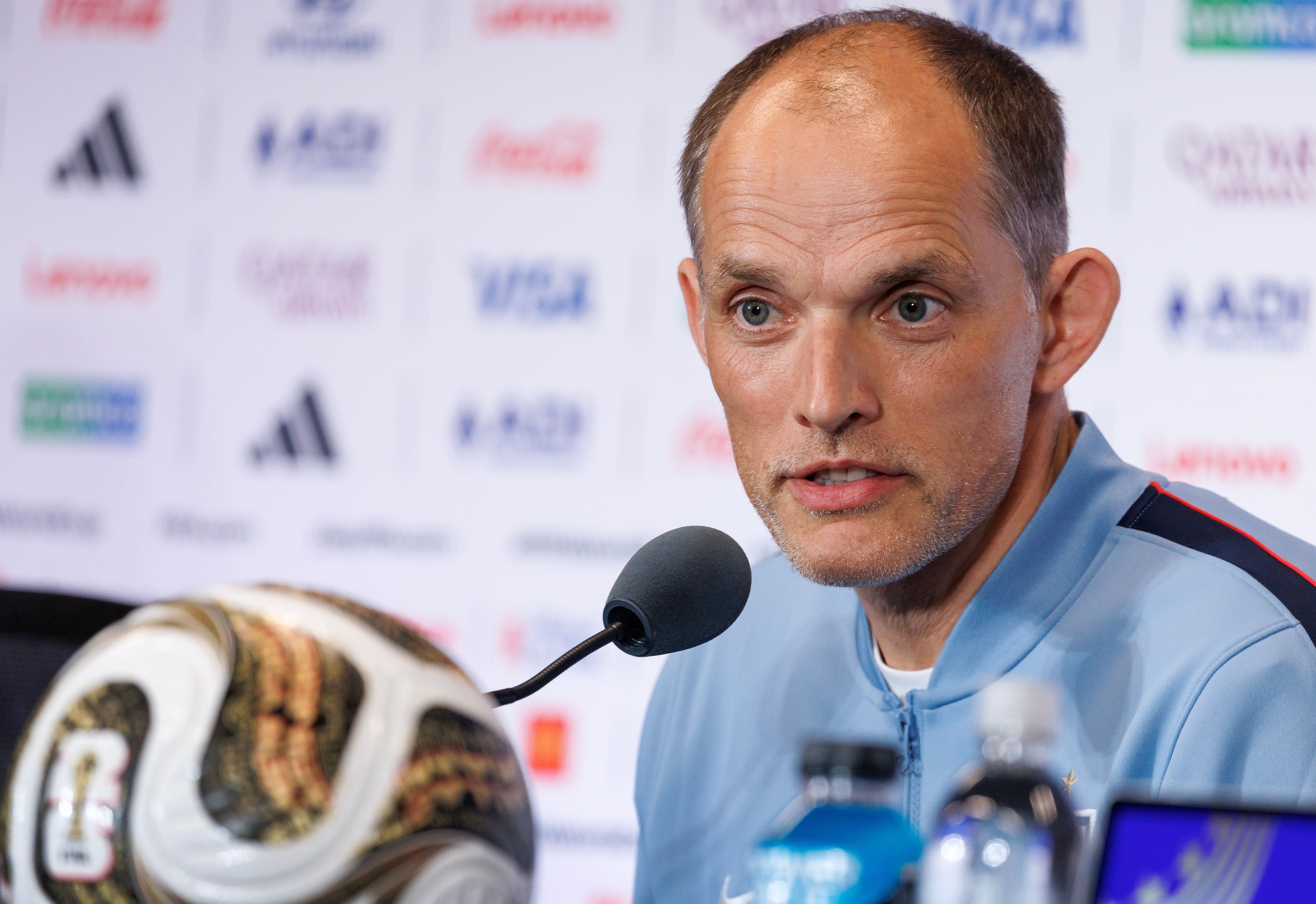 Ein Mann spricht auf einer Pressekonferenz, vor ihm ein Mikrofon und ein Fußball.