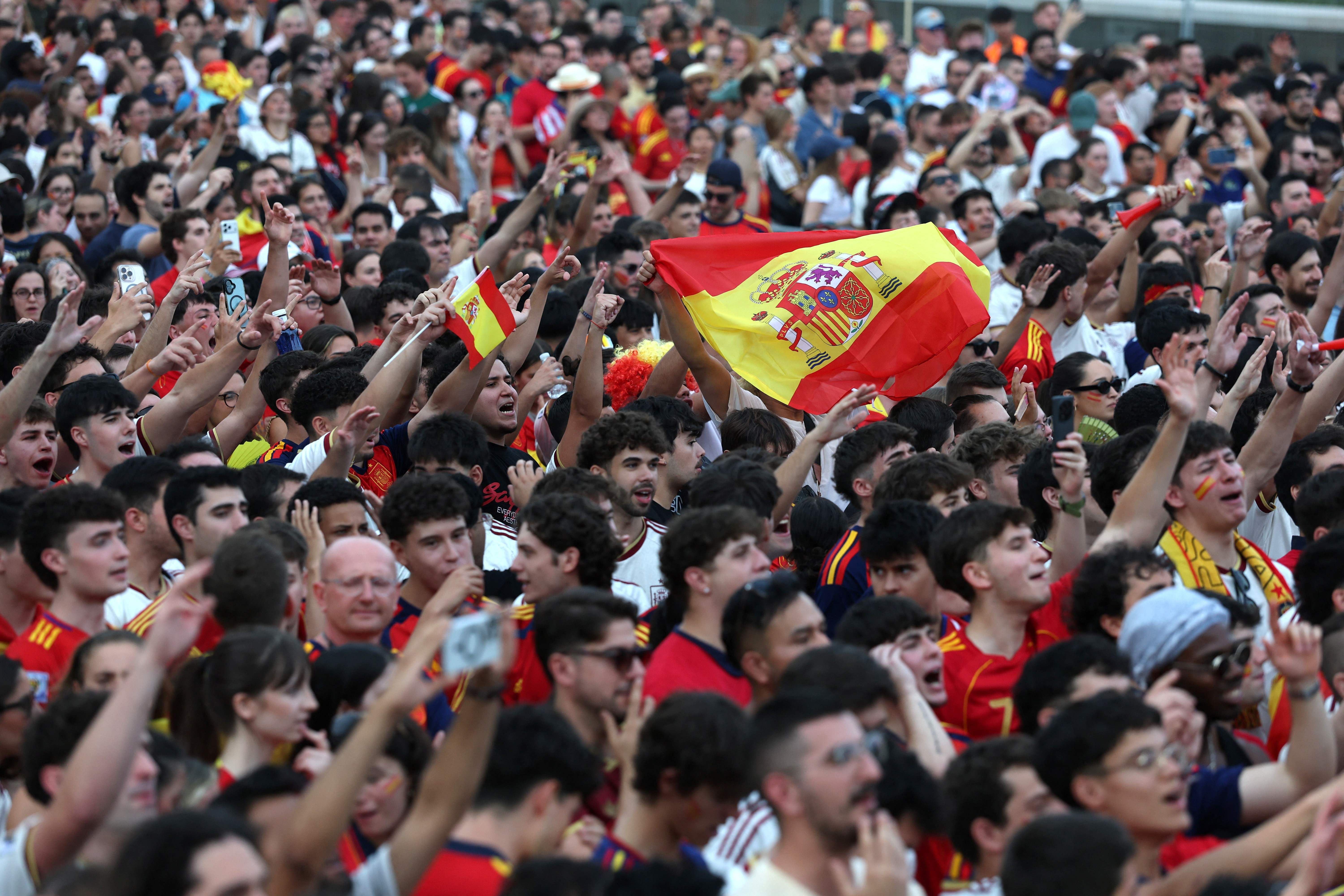 Jubelnde spanische Fans mit Flaggen und Trikots bei einer Fan-Zone in Madrid.