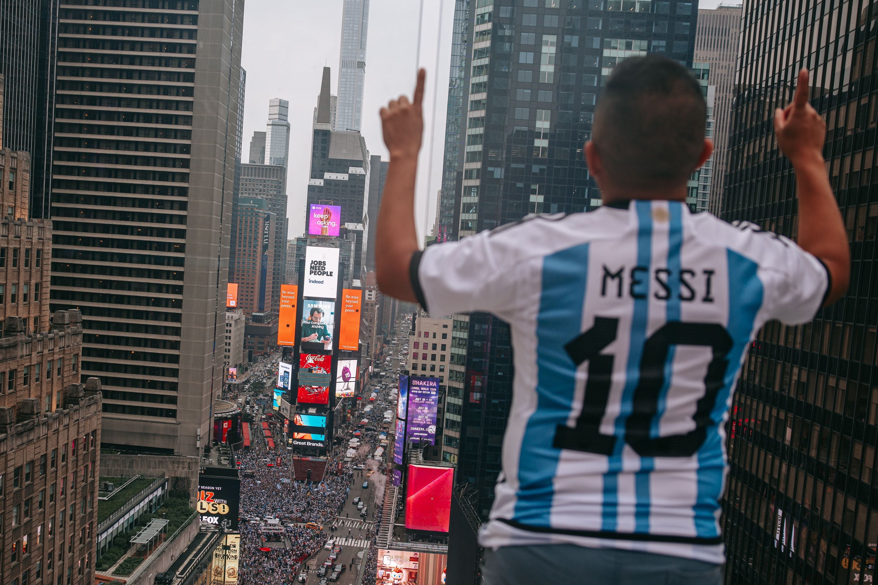 Ein Fan im Messi-Trikot jubelt über Menschenmenge am Times Square in New York.