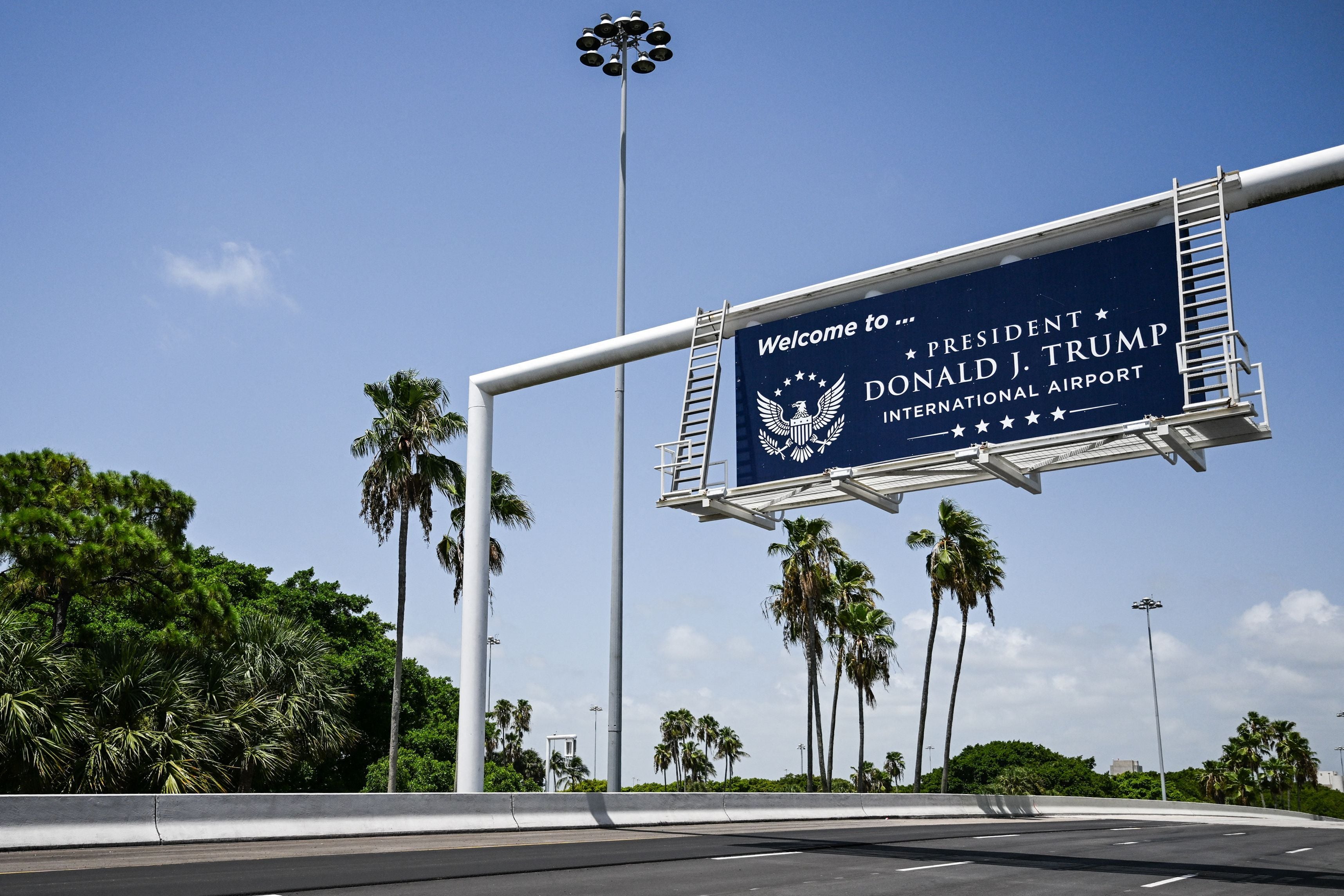 Ein Schild „Welcome to President Donald J. Trump International Airport“ an einer Zufahrtsstraße.
