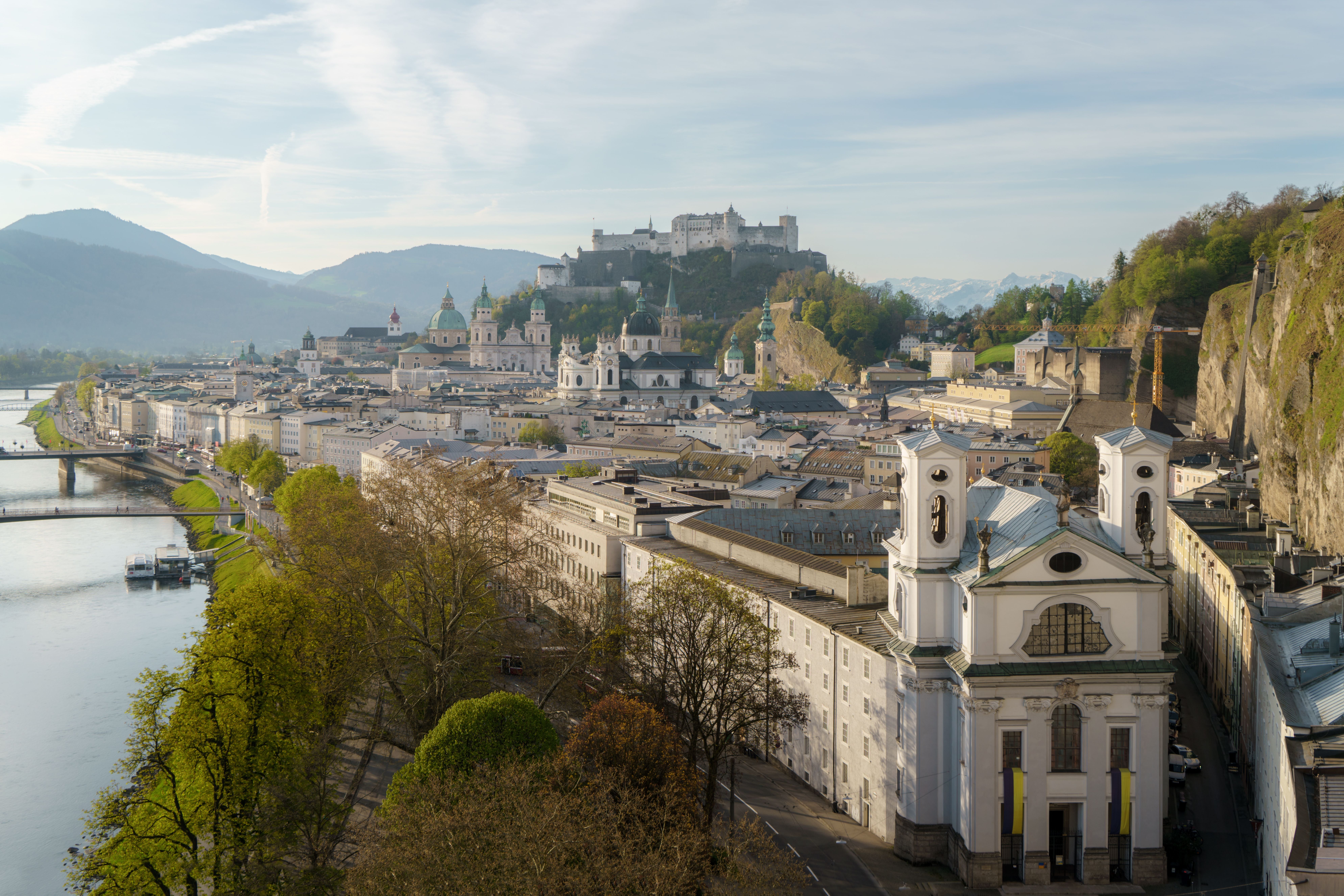 Panorama von Salzburg mit barocken Kuppeln, Altstadt und der Festung Hohensalzburg auf einem Hügel.