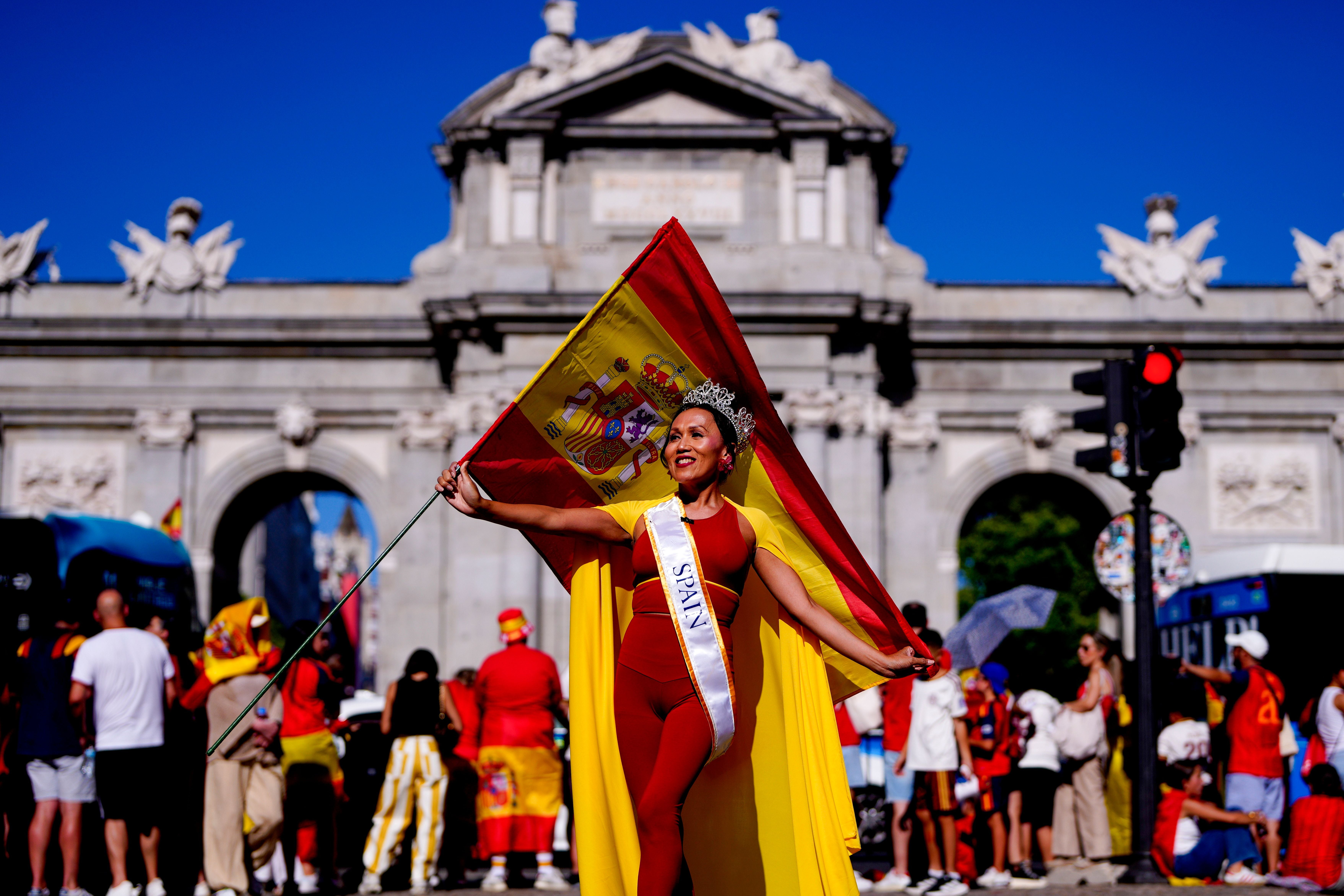 Eine Frau mit Krone und Spanien-Fahne feiert im Zentrum Madrids.