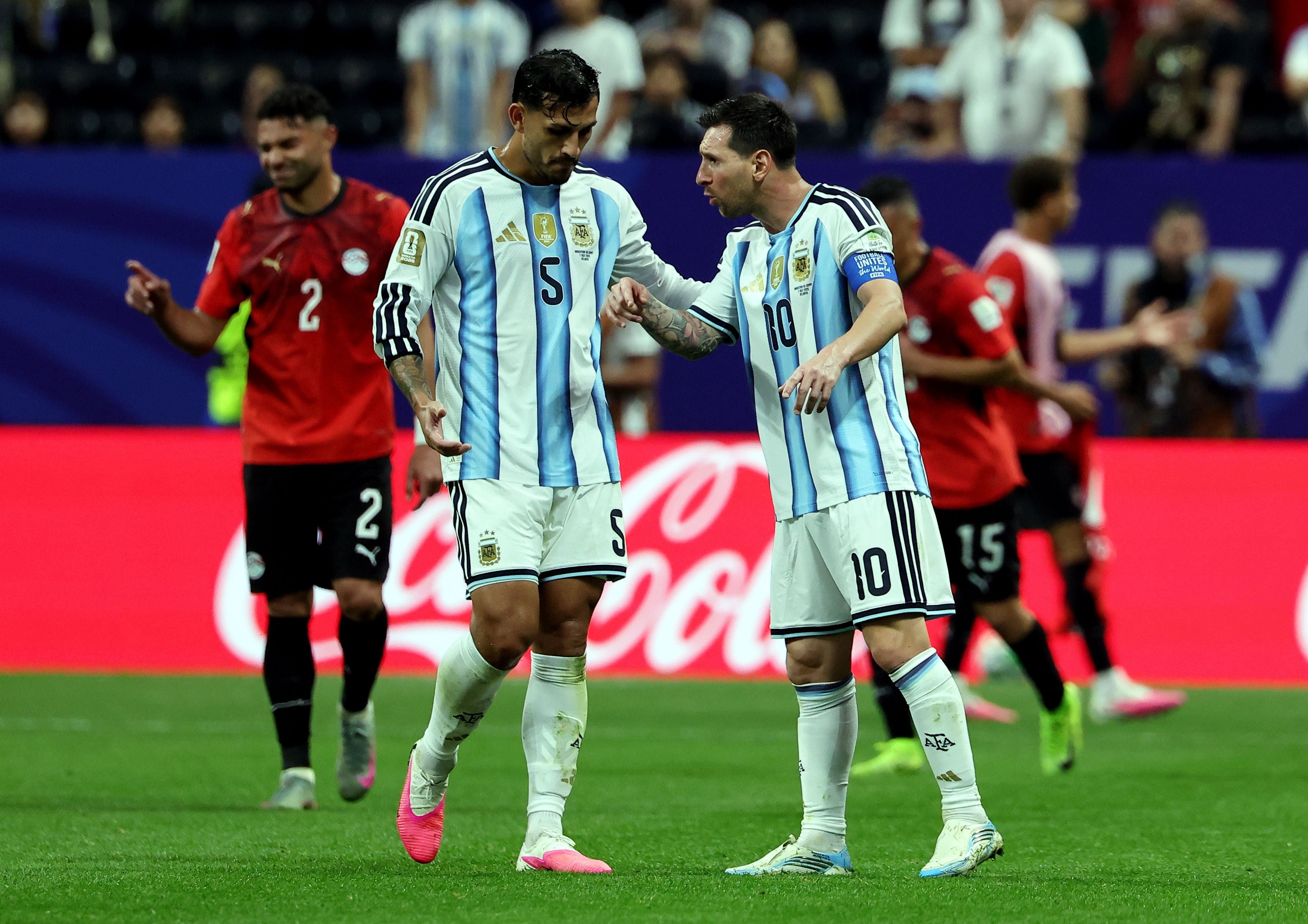 Zwei argentinische Fußballspieler sprechen sich während eines Spiels gegen Ägypten auf dem Feld ab.
