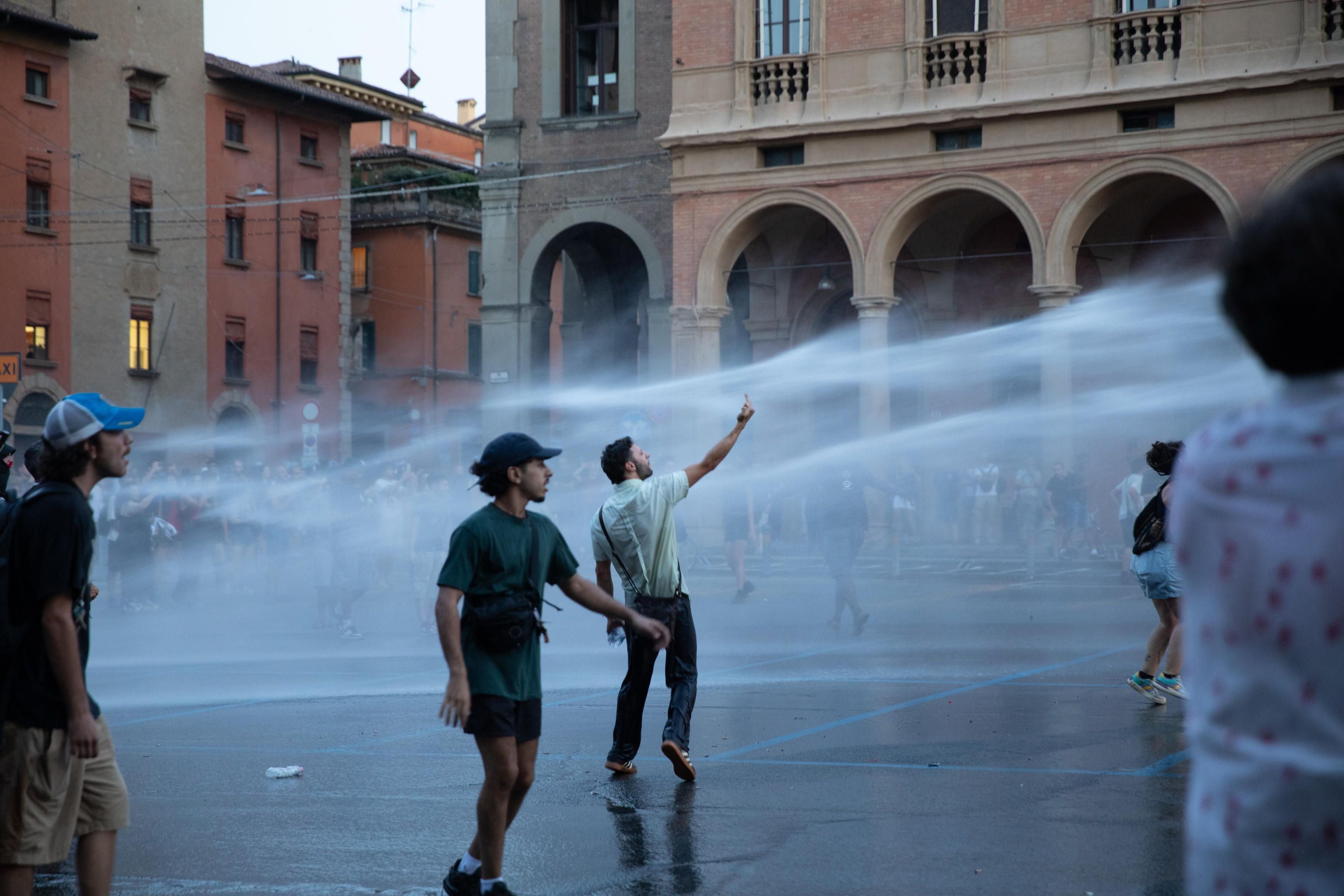 Polizei setzt Wasserwerfer bei einer Demonstration auf einem Platz in Bologna ein.