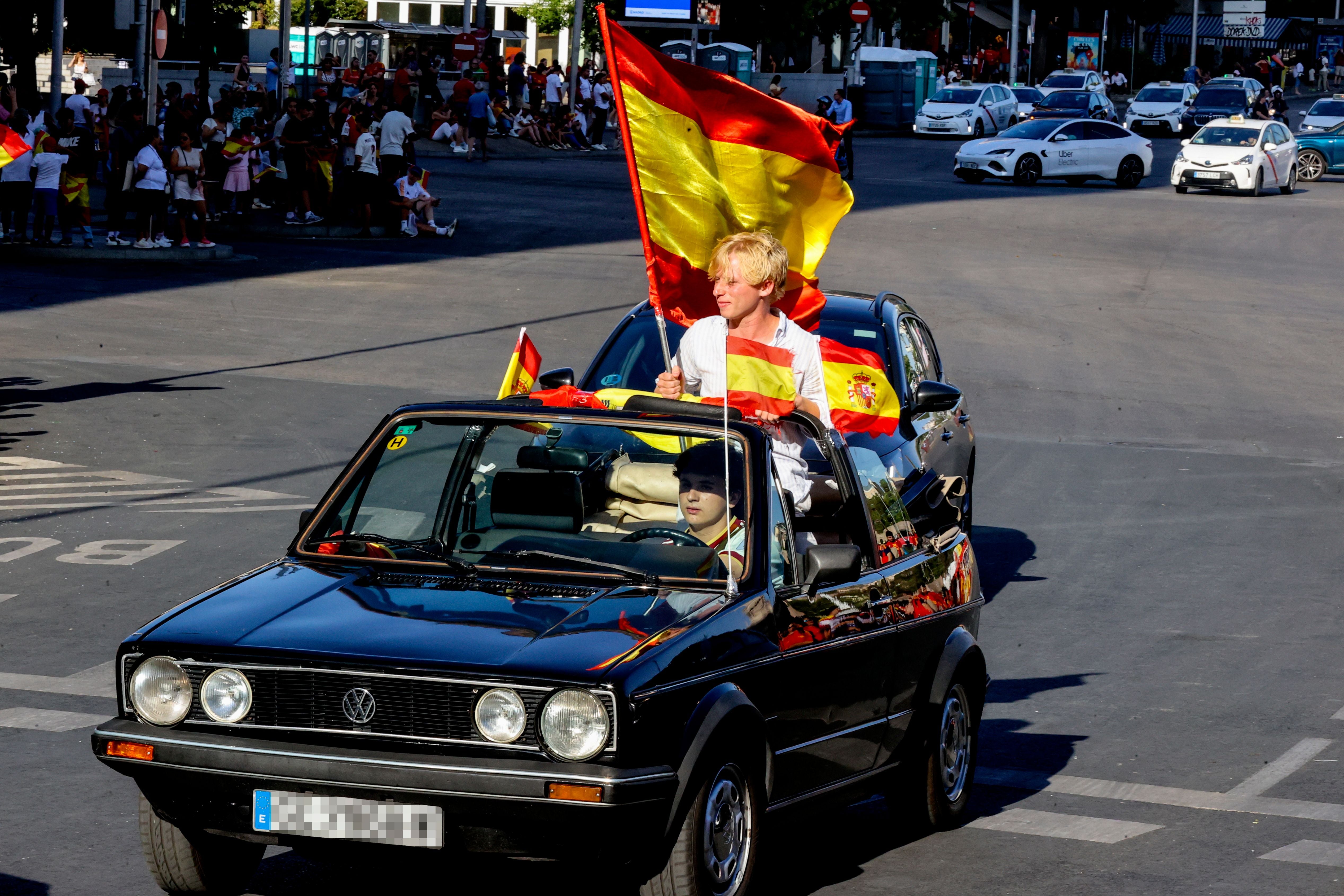 Spanische Fans feiern im Auto mit Flaggen während einer Parade in Madrid.