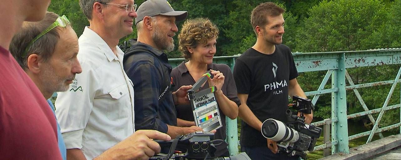 Filmteam mit Kameraausrüstung auf einer historischen Brücke in Hardegg, umgeben von Natur.
