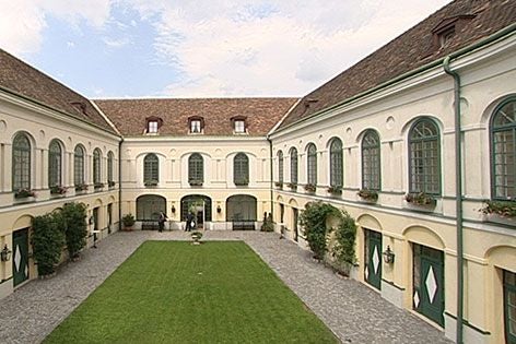 Schöner Innenhof des Grand Hotels Sauerhof mit Rasenfläche und umliegenden historischen Gebäuden.