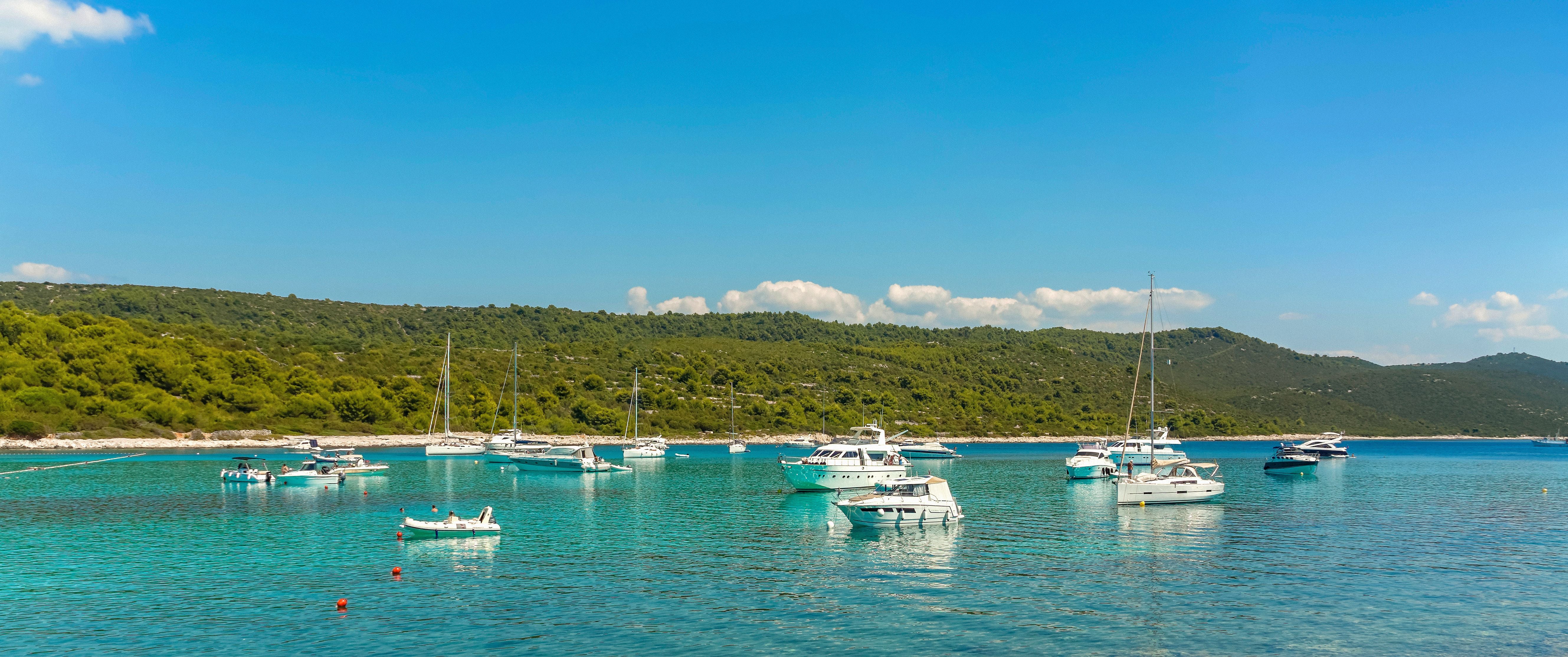 Mehrere Yachten liegen in der blauen Sakarun-Bucht vor Dugi Otok, Kroatien, vor Anker.