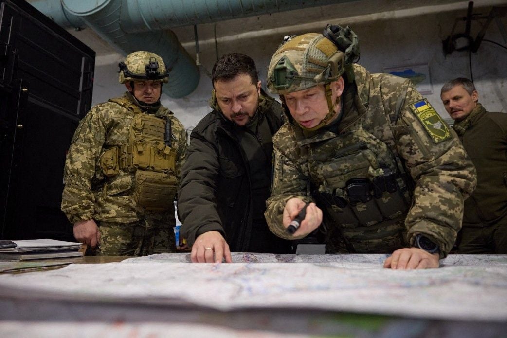 Ukraine-Präsident Selenskyj und Oberbefehlshaber Syrskyj betrachten gemeinsam eine große Landkarte auf einem Tisch.