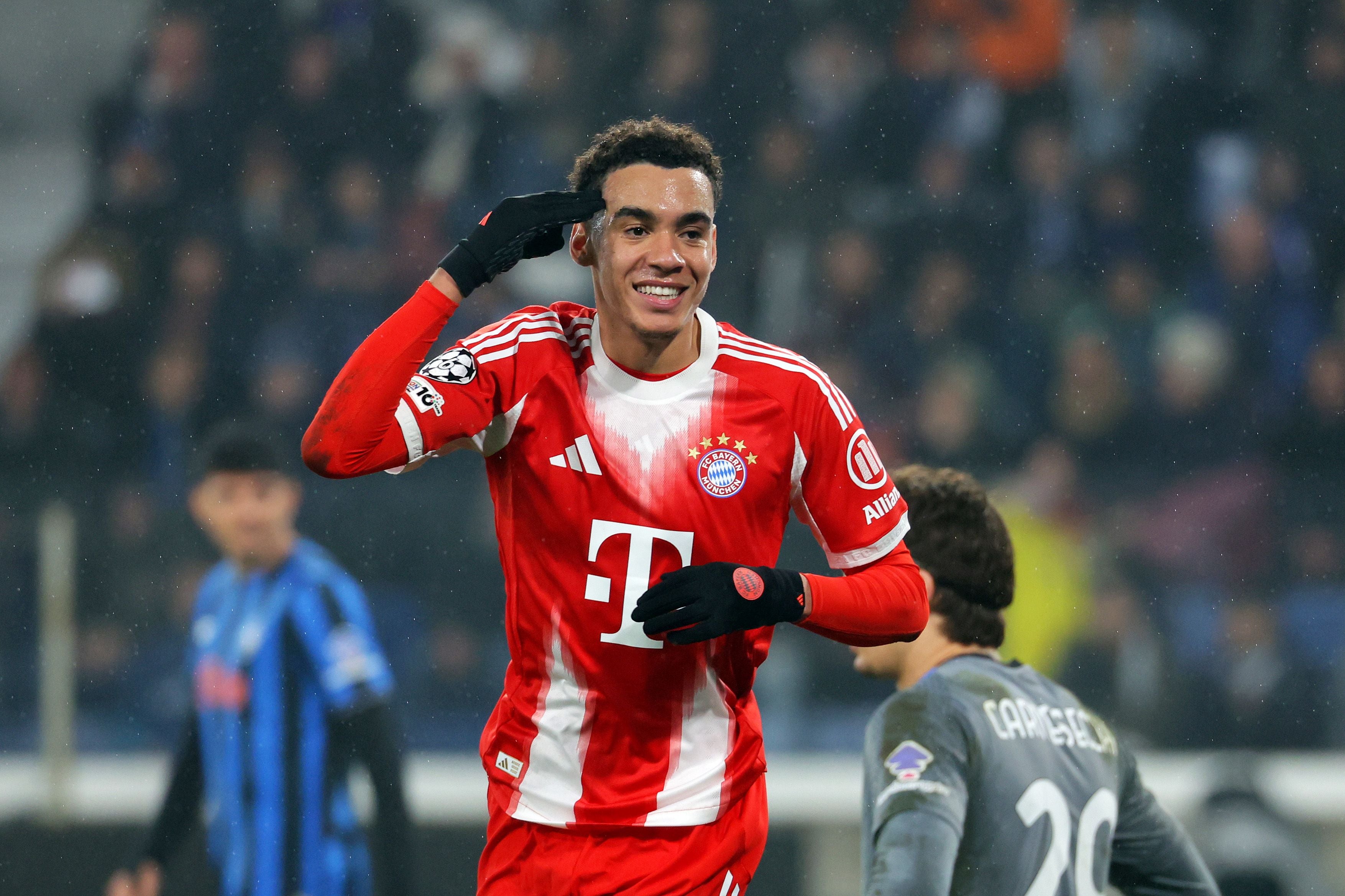 Ein Fußballspieler des FC Bayern jubelt auf dem Spielfeld mit einer Salut-Geste.