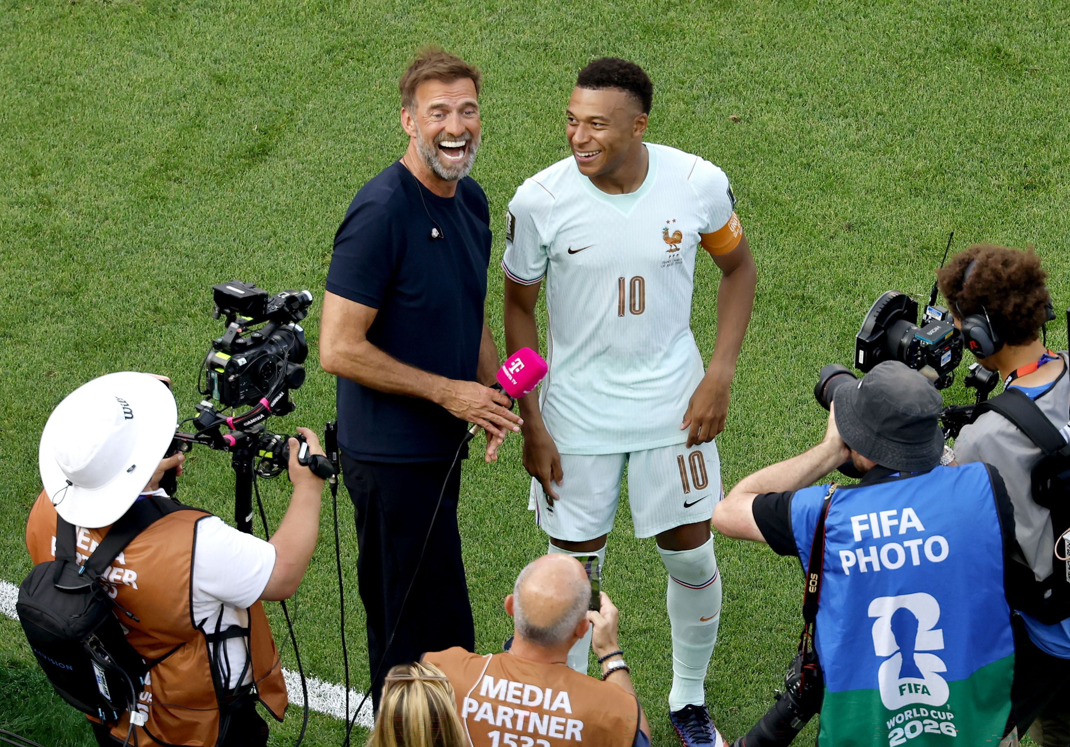 Der französische Superstar Kylian Mbappé (r.) im Gespräch mit dem deutschen Star-Trainer und TV-Experten Jürgen Klopp nach dem Sieg Frankreichs im Viertelfinalspiel der FIFA-Weltmeisterschaft 2026 gegen Marokko in Boston, USA, am 9. Juli 2026.