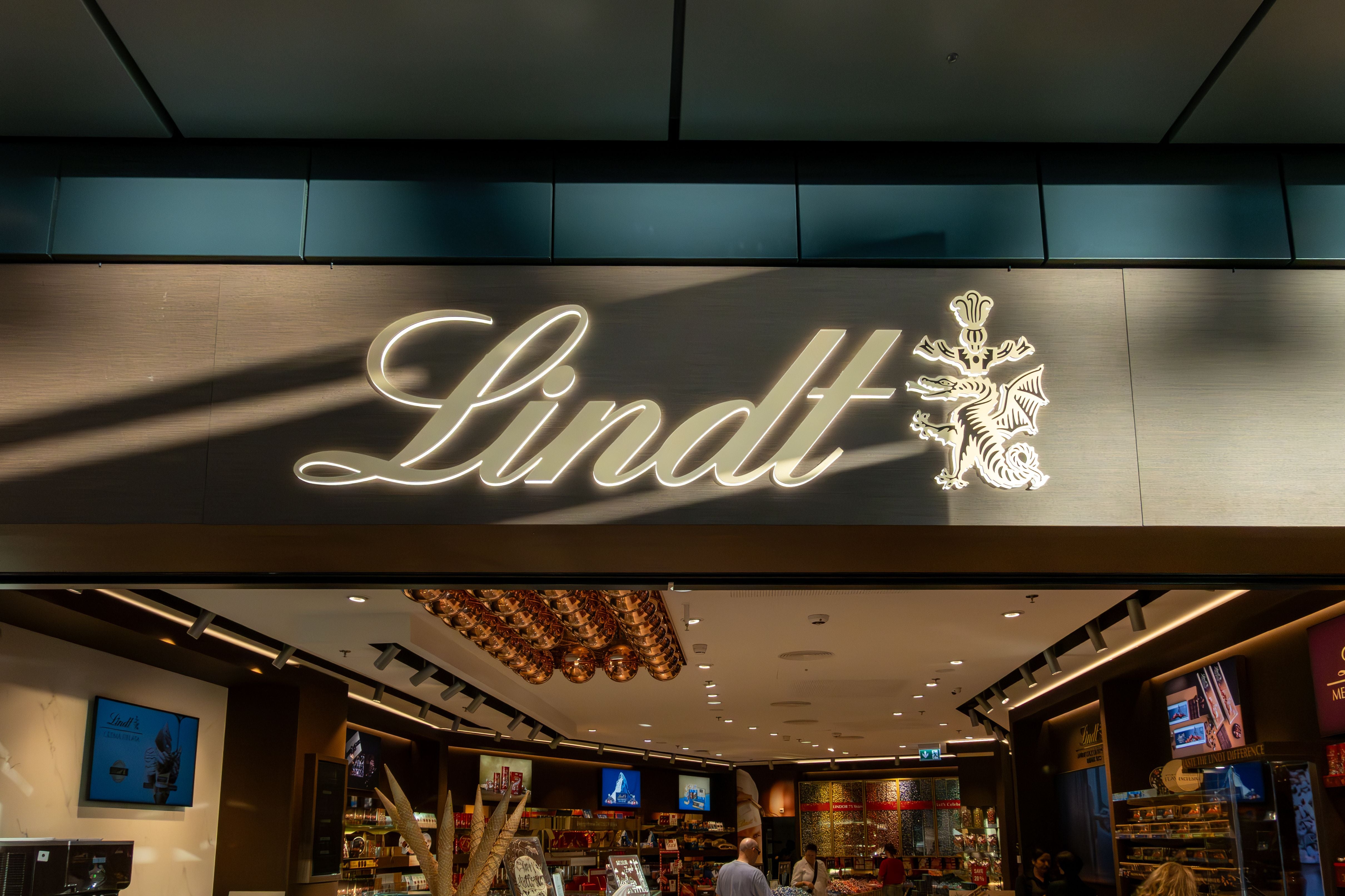 Leuchtendes Lindt-Schild über dem Eingang eines Schokoladengeschäfts in Zürich.