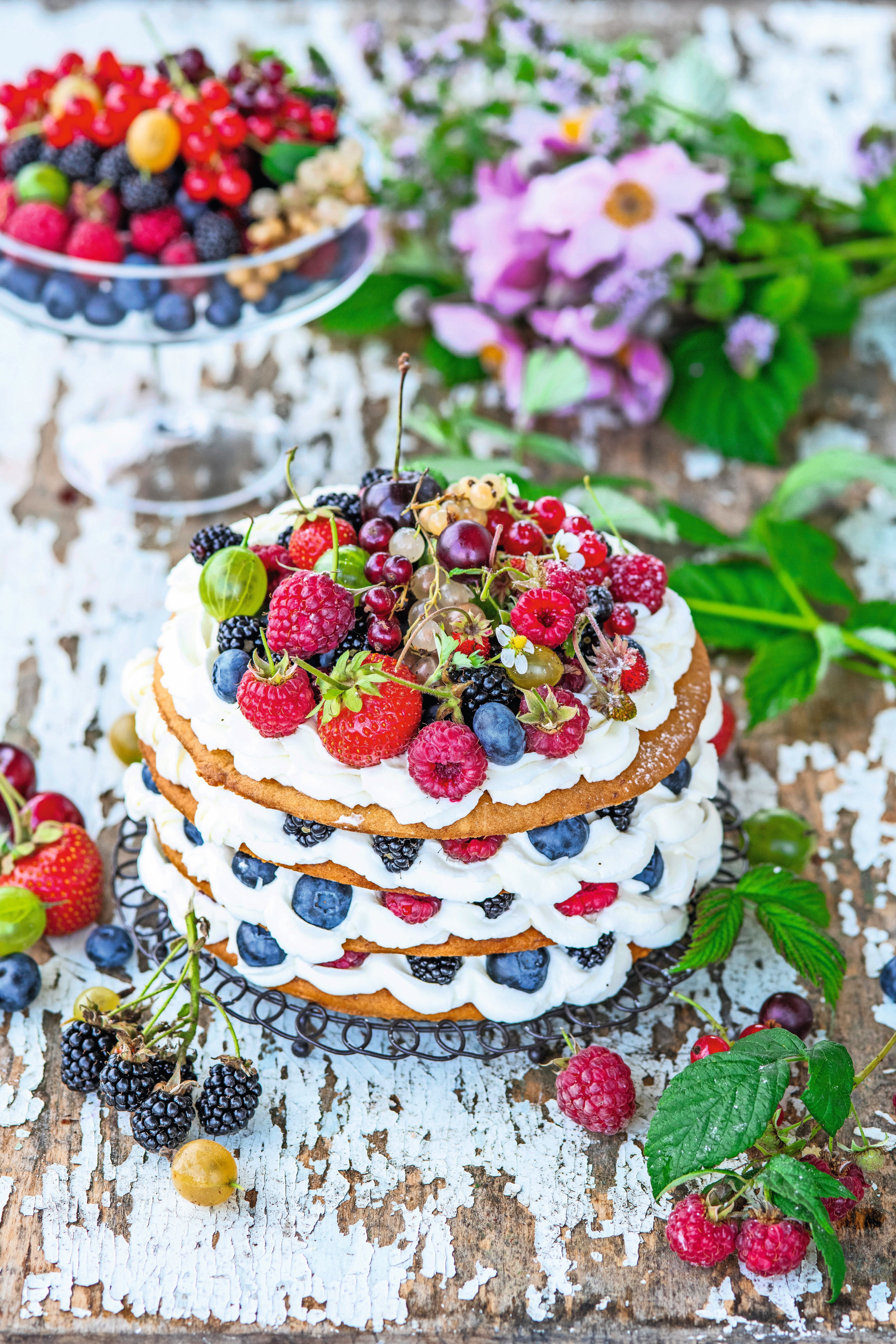 Schichtkuchen mit Mascarpone, Honig und frischen Beeren, dekorativ angerichtet.