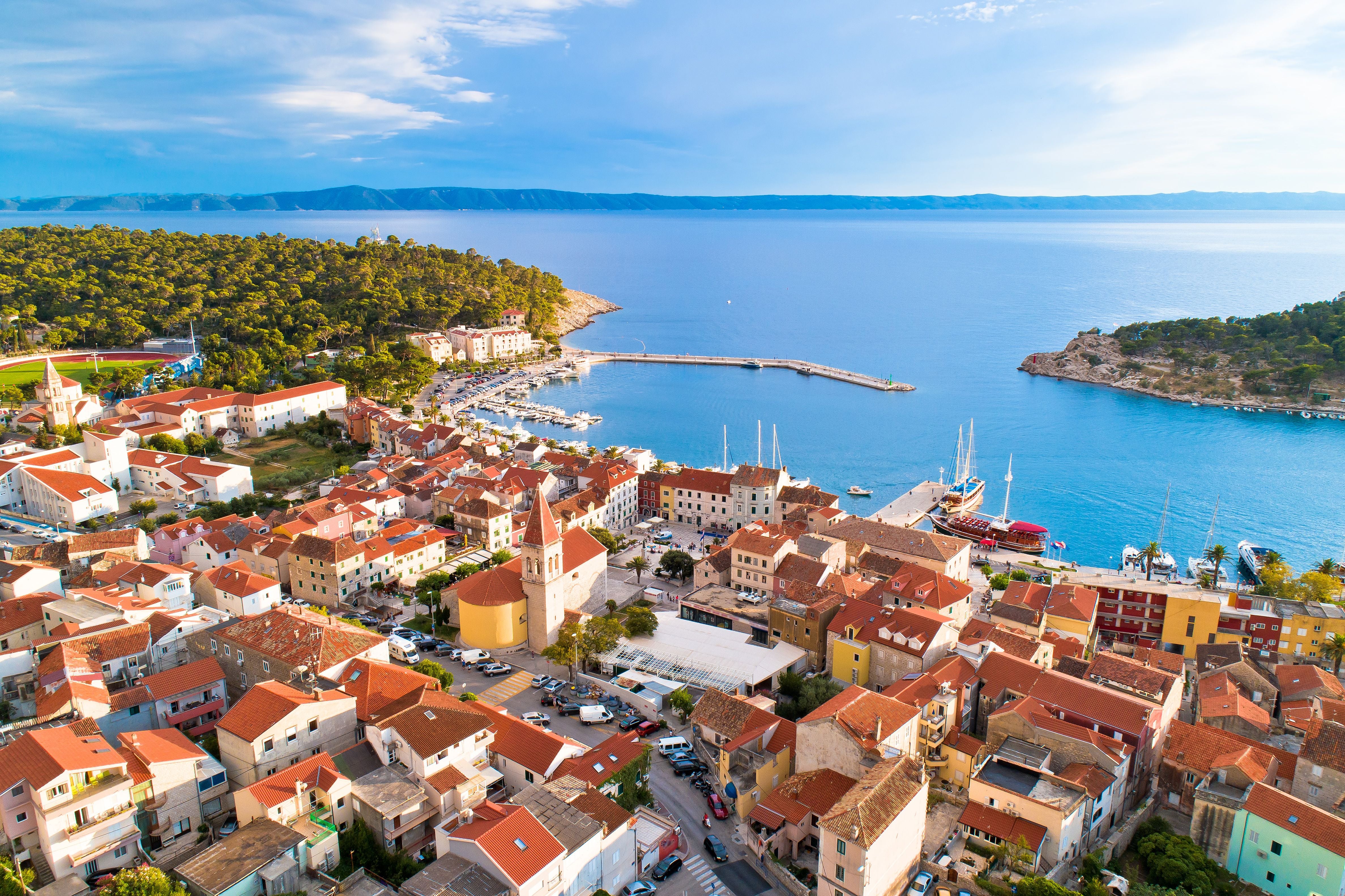 Luftaufnahme der Küstenstadt Makarska mit Altstadt, Hafen und blauem Meer in Kroatien.