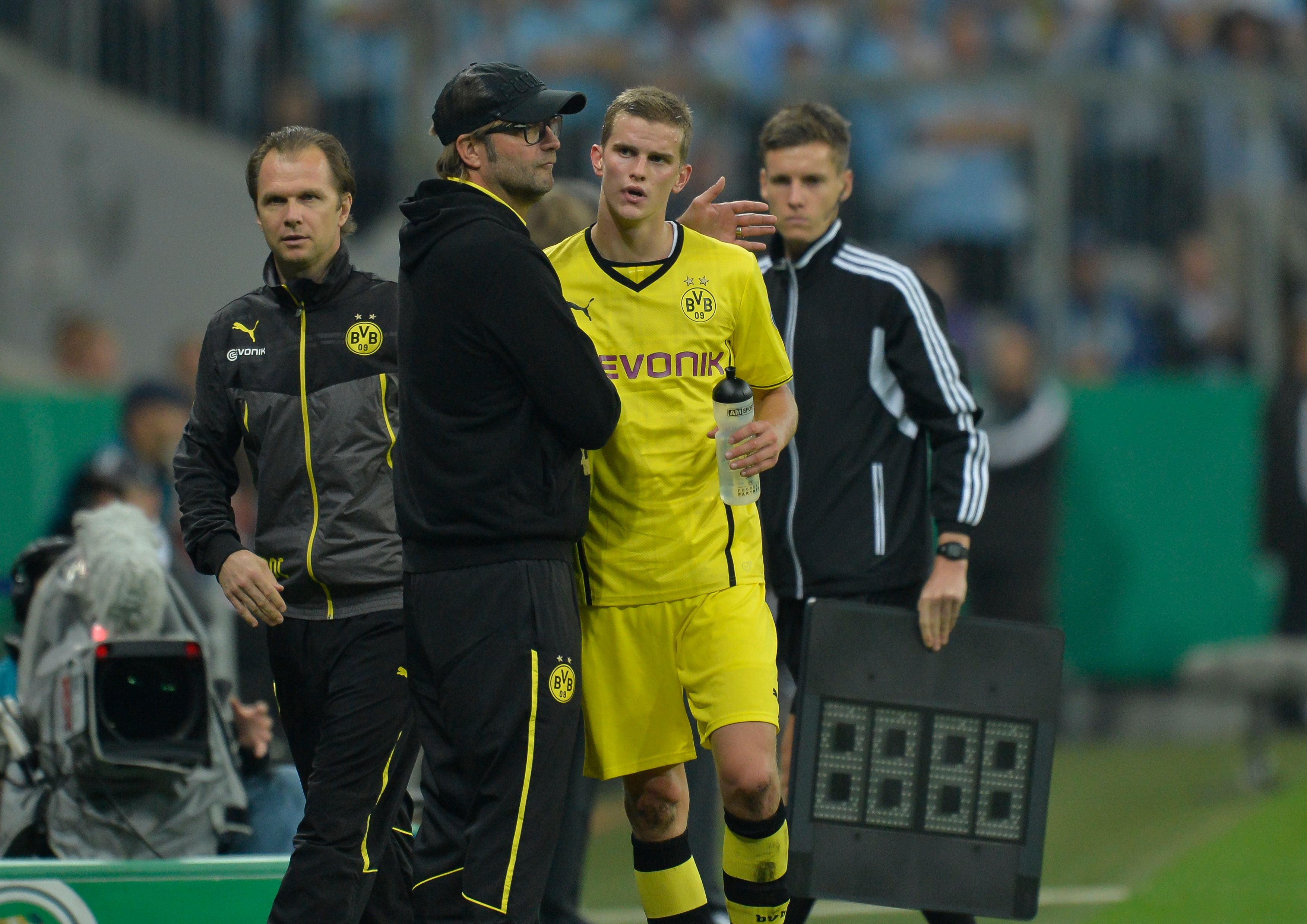 Trainer und Spieler von Borussia Dortmund unterhalten sich während eines Fußballspiels am Spielfeldrand.