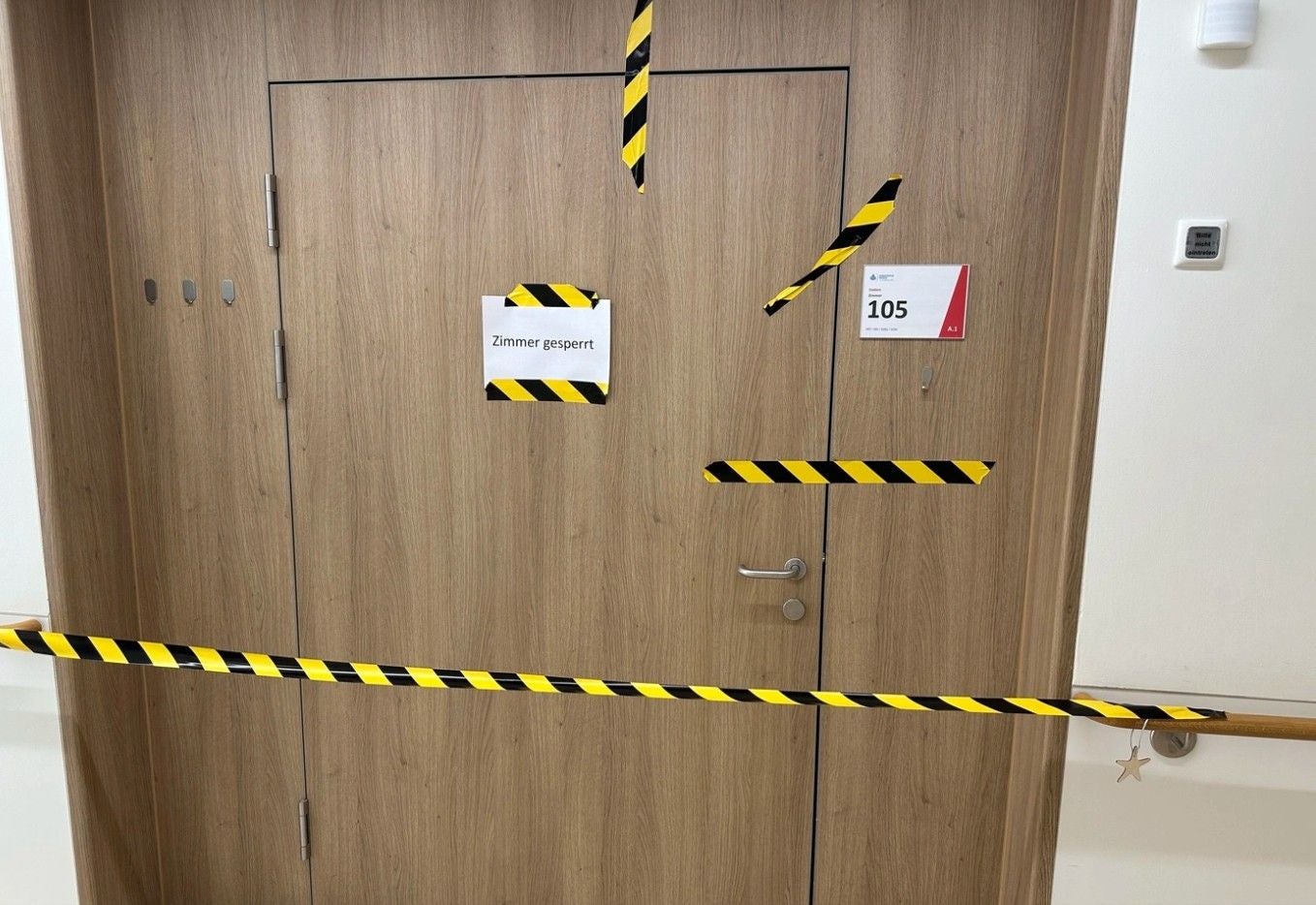 Holztür mit Warnband und Schild "Zimmer gesperrt" vor Zimmer 105 nach einer Explosion abgesperrt.