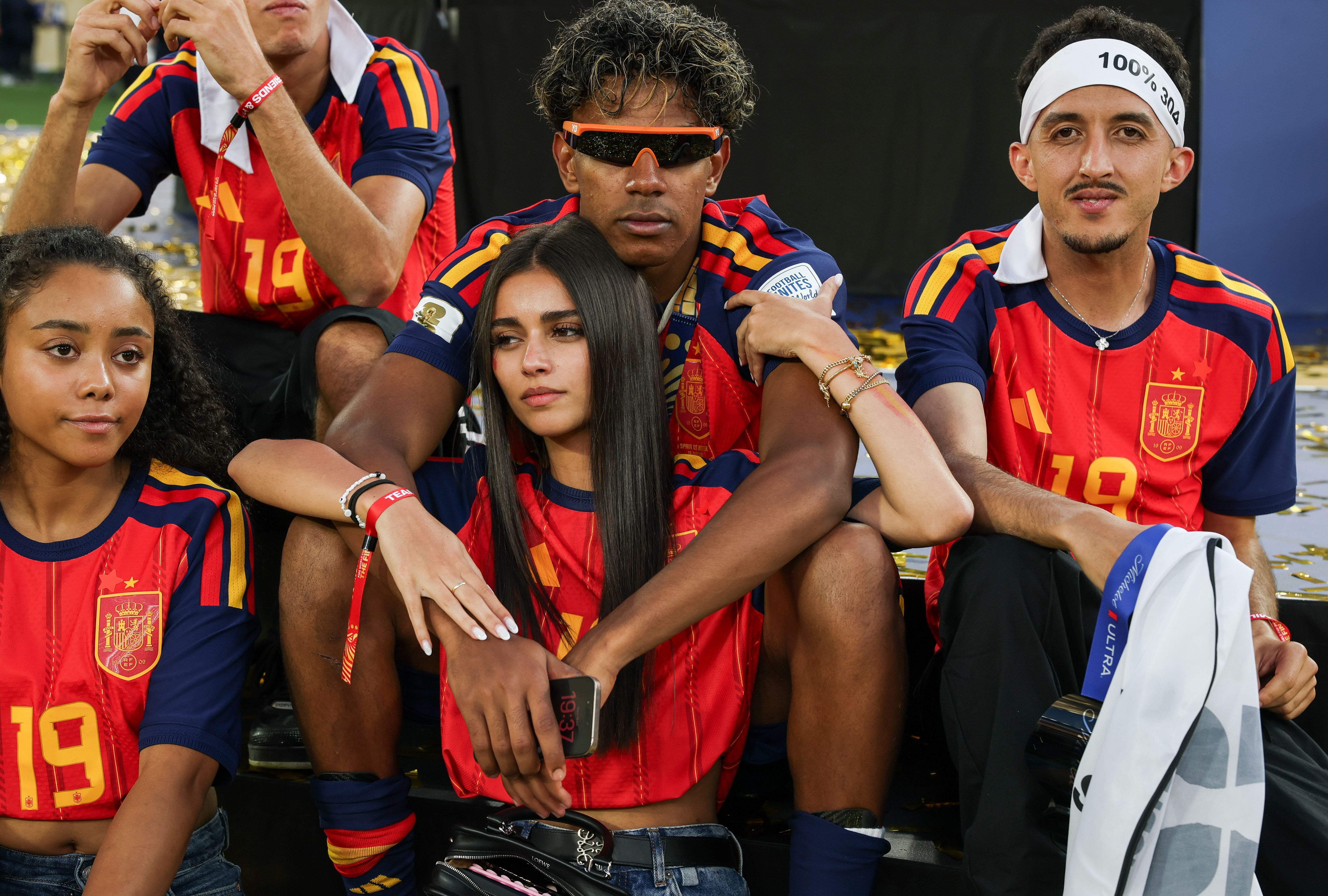Vier junge Menschen in Spanien-Trikots feiern gemeinsam im Stadion.