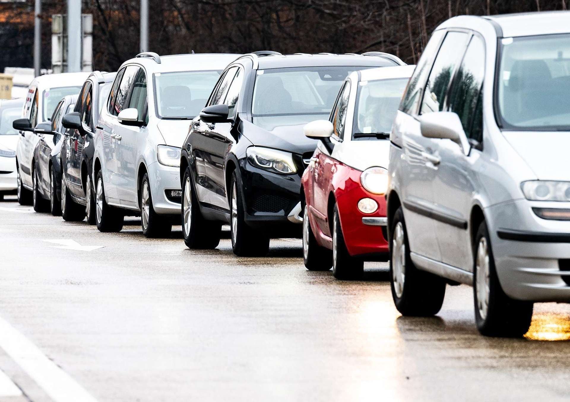 Mehrere Autos stehen auf einer nassen Straße im Stau.