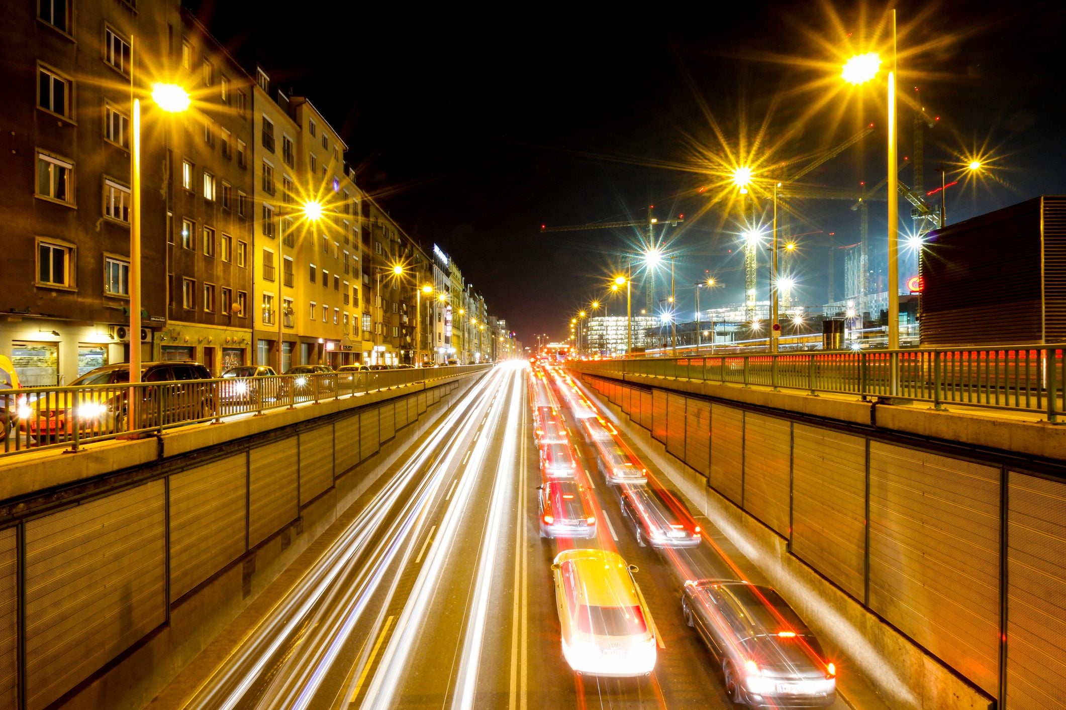Starker Nachtverkehr in Wien mit Lichtspuren und beleuchteten Straßenlaternen.